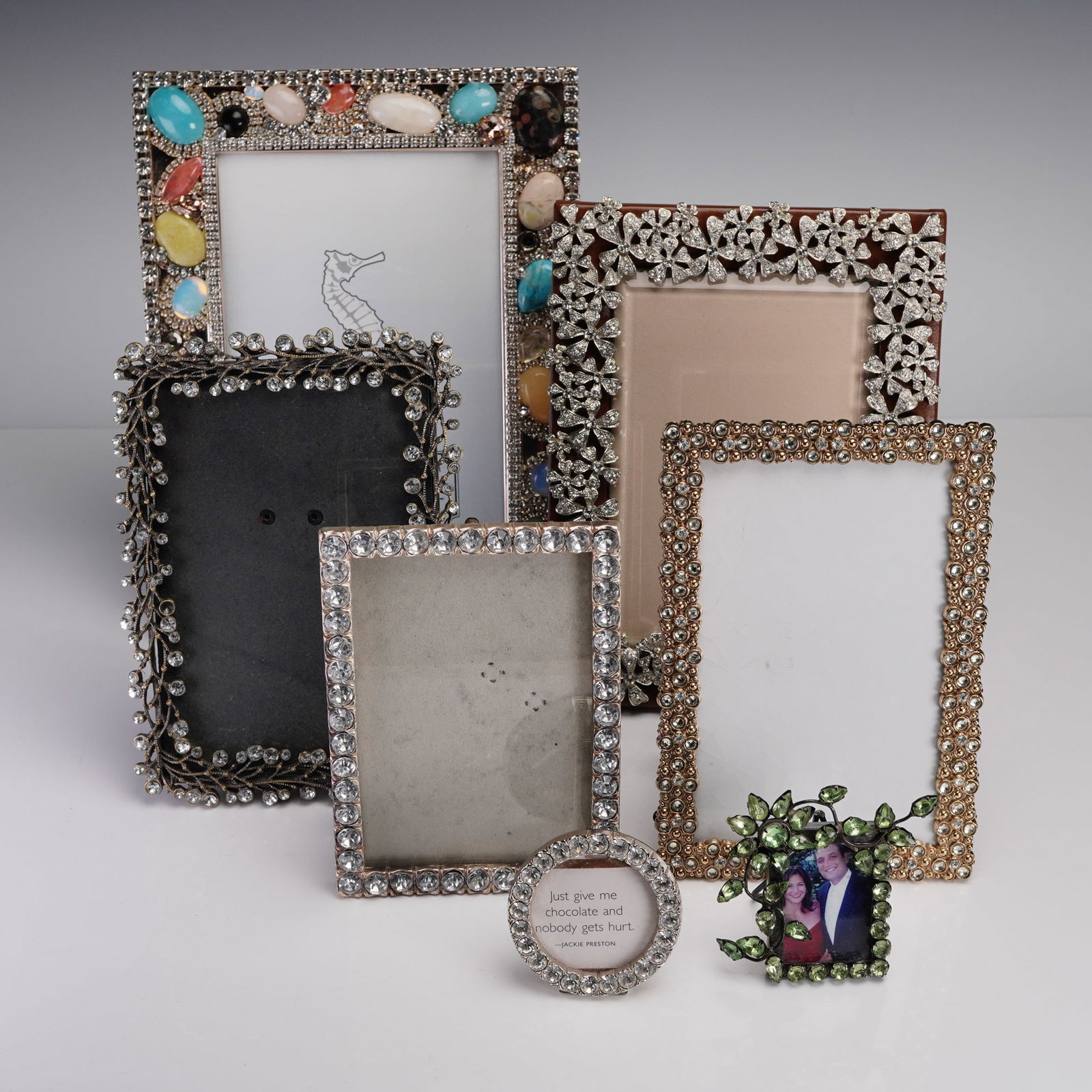 7pc Rhinestone and Crystal Embellished Picture Frames: A group of seven rhinestone and crystal embellished picture frames, ranging in height from approximately 3 inches to 9 inches. This elegant collection includes a variety of ornate styles, such as a vi
