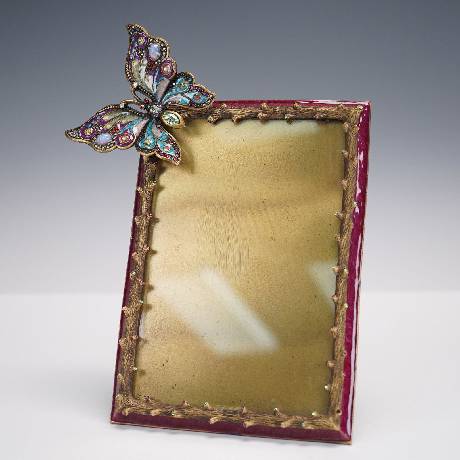 Jay Strongwater Jeweled Butterfly Picture Frame: Jay Strongwater jeweled butterfly picture frame featuring a rectangular form with deep red enamel sides and a sculpted gold tone twig motif border, accented by a large multicolored butterfly in enamel