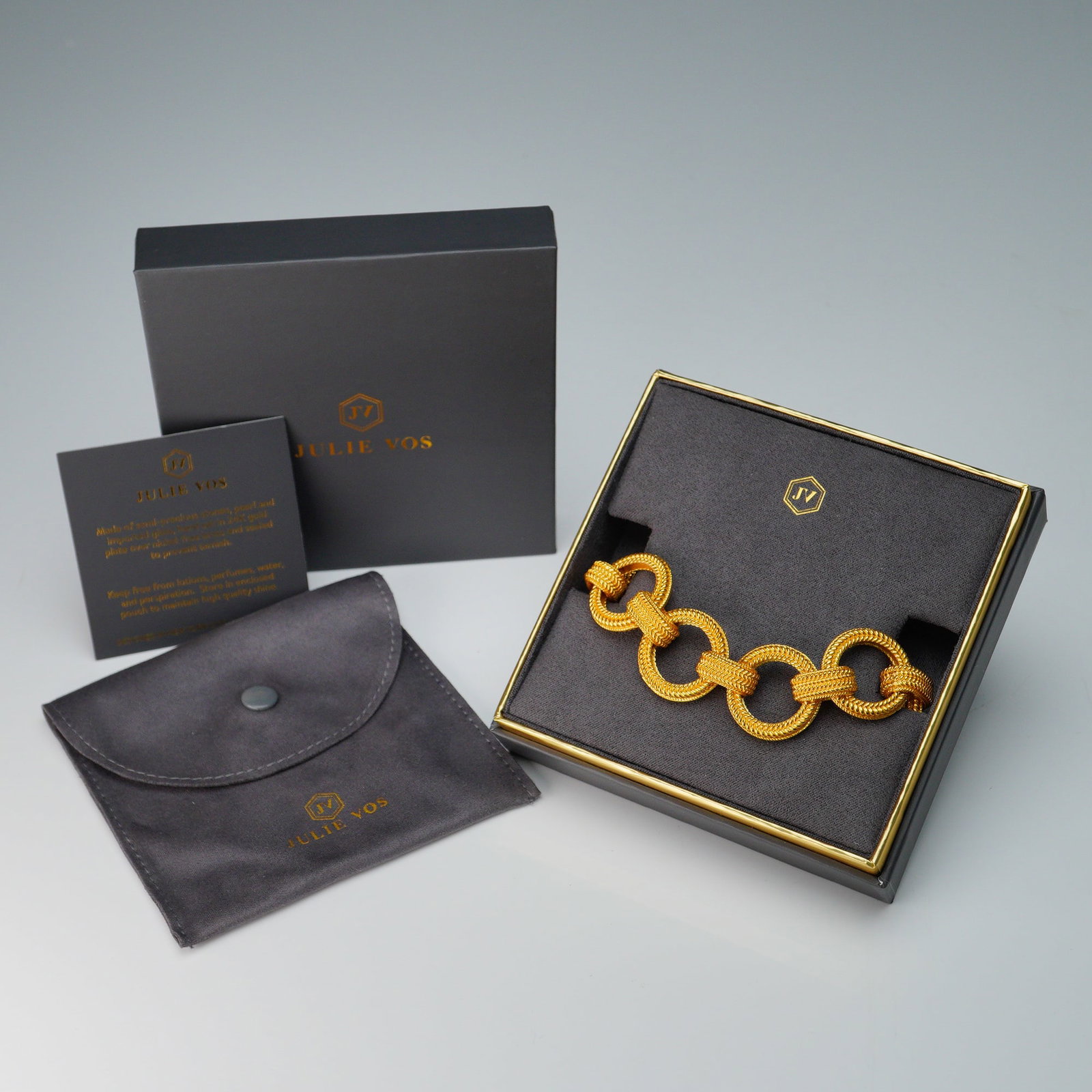 Julie Vos Gold Link Toggle Bracelet With Box: Bold gold-tone bracelet by Julie Vos featuring oversized textured circular links joined by matching ridged connectors. The piece secures with a coordinating toggle clasp and is adorned with a signatur