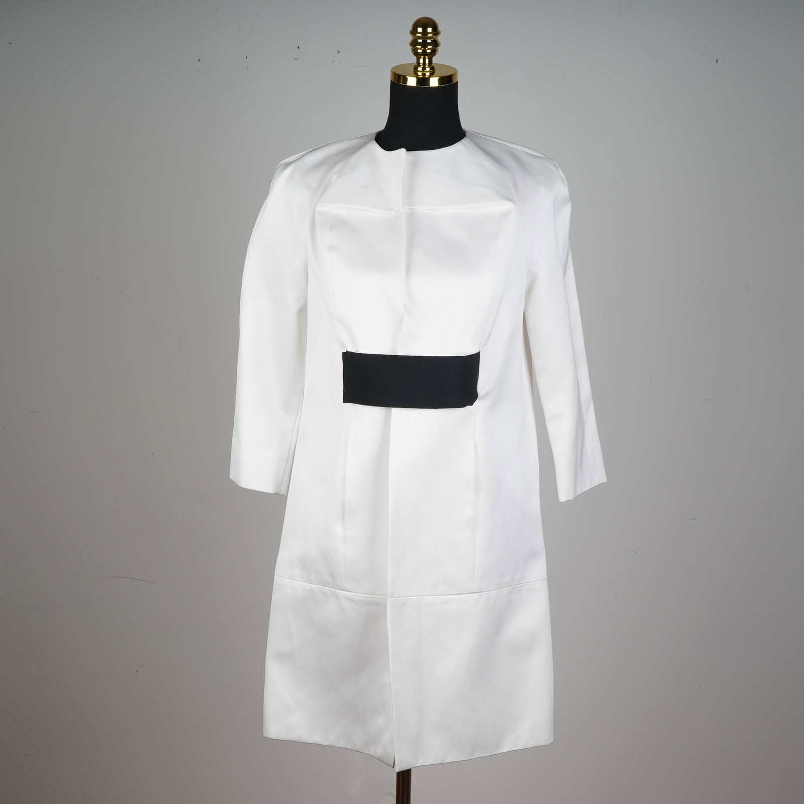 KISA White Structured Dress Coat with Black Waist Cinch: Command attention with this bold and contemporary KISA white structured dress coat, featuring a dramatically architectural silhouette enhanced by sharp tailoring and striking contrasts. The standout f