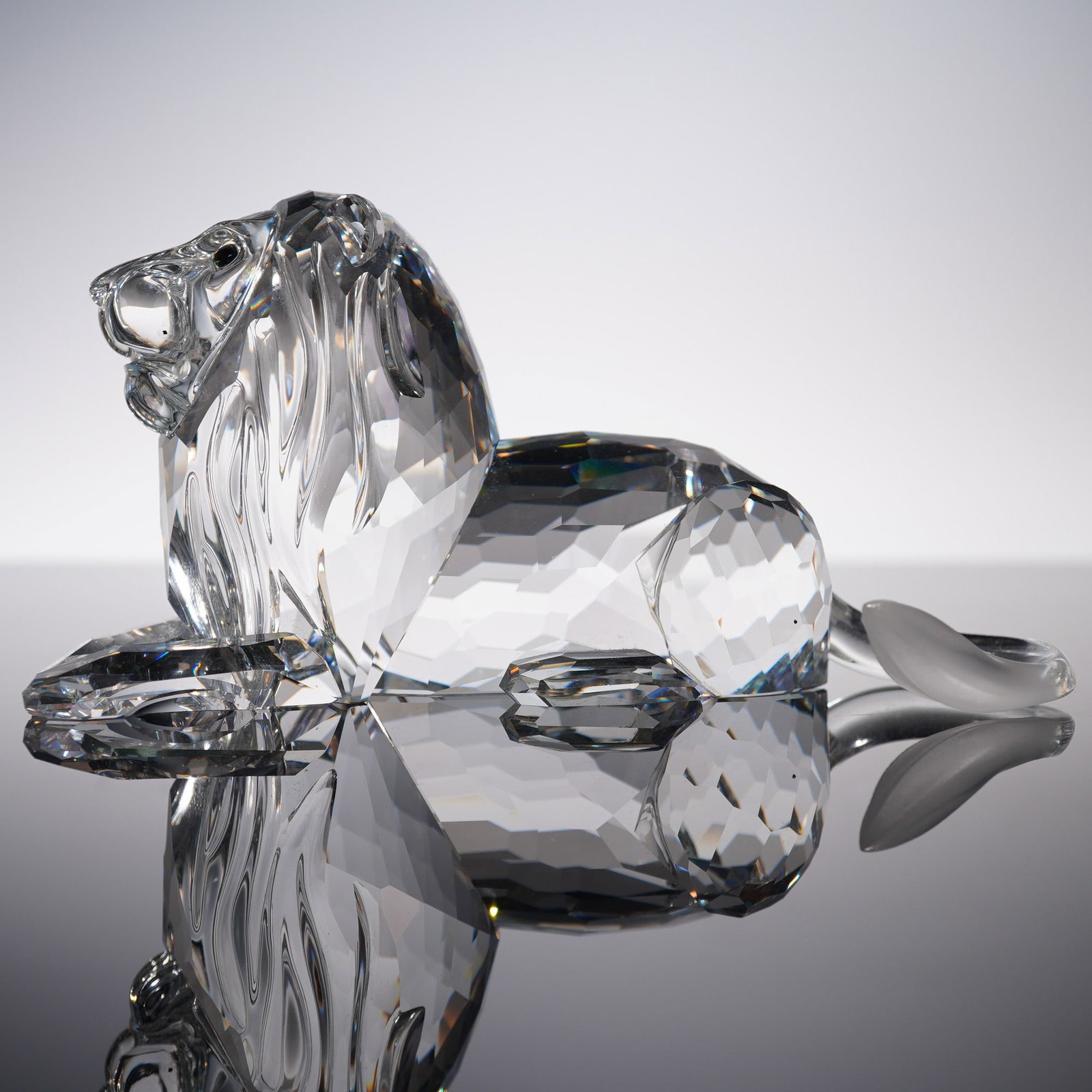 Swarovski Crystal Figurine, Lion 185410: Part of the Inspiration Africa trilogy, this annual edition lead crystal lion is crafted in clear crystal and seated gracefully on all fours. The frosted tip of its tail adds a subtle contrast to the 