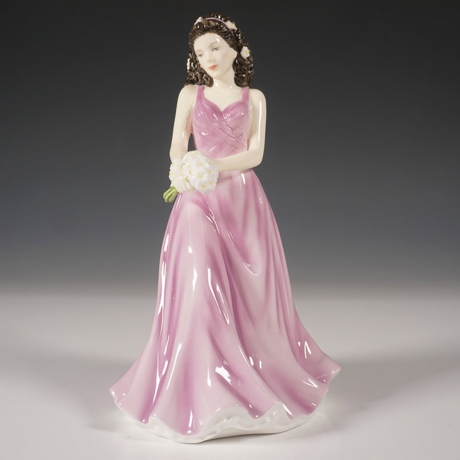 Royal Doulton Flower of the Month Figurine, April HN5503: This exquisite Royal Doulton figurine, April Daisy Innocence (HN5503), is part of the Flower of the Month collection. Crafted from fine bone china, it showcases a graceful young woman in a flowing lil