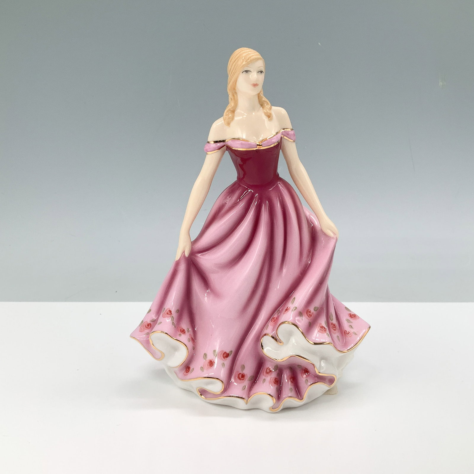 Royal Doulton Pretty Ladies Figurine, Good Friend HN 5578: This Royal Doulton Pretty Ladies figurine, titled Good Friend, HN 5578, showcases a graceful young woman in an elegant flowing gown with delicate floral detailing and gold accents. The hand-decorated 