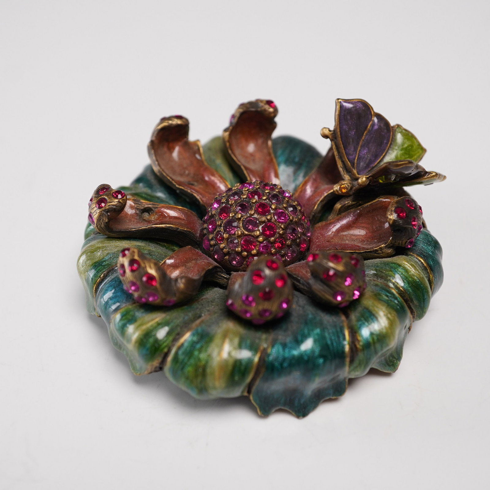 Jay Strongwater Jeweled Flower with Butterfly Figurine: Jay Strongwater jeweled tabletop decor in the form of an open flower, featuring richly enameled petals in shades of green, rose, and violet, accented by a butterfly and pink rhinestones. Jay Strongwat