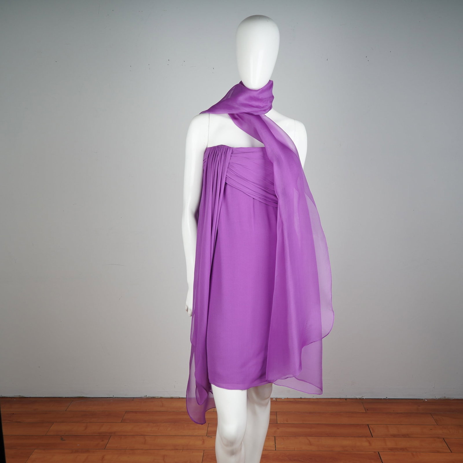 Striking Lilac Strapless Cocktail Dress with Flowing Chiffon Scarf: Make an unforgettable entrance with this vibrant lilac cocktail dress, a masterclass in soft elegance and bold style. This strapless design is beautifully tailored in layers of lightweight chiffon, ar
