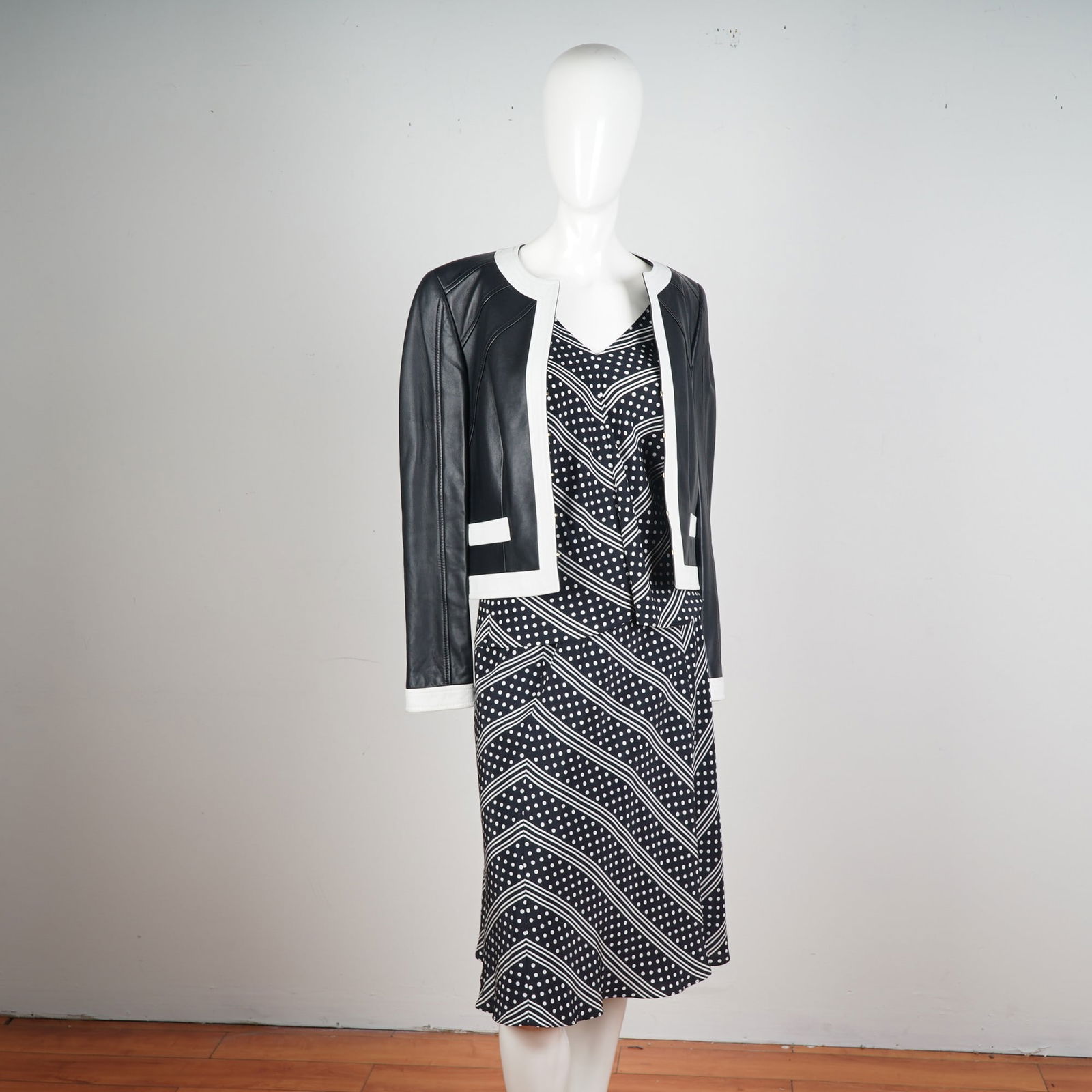 Escada 3pc Polka Dot Leather Trim Jacket, Skirt and Slip: A standout 3-piece ensemble by Escada, blending classic pattern with sophisticated structure. The set includes a sleeveless black and white polka dot midi skirt adorned with chevron stripe detailing,