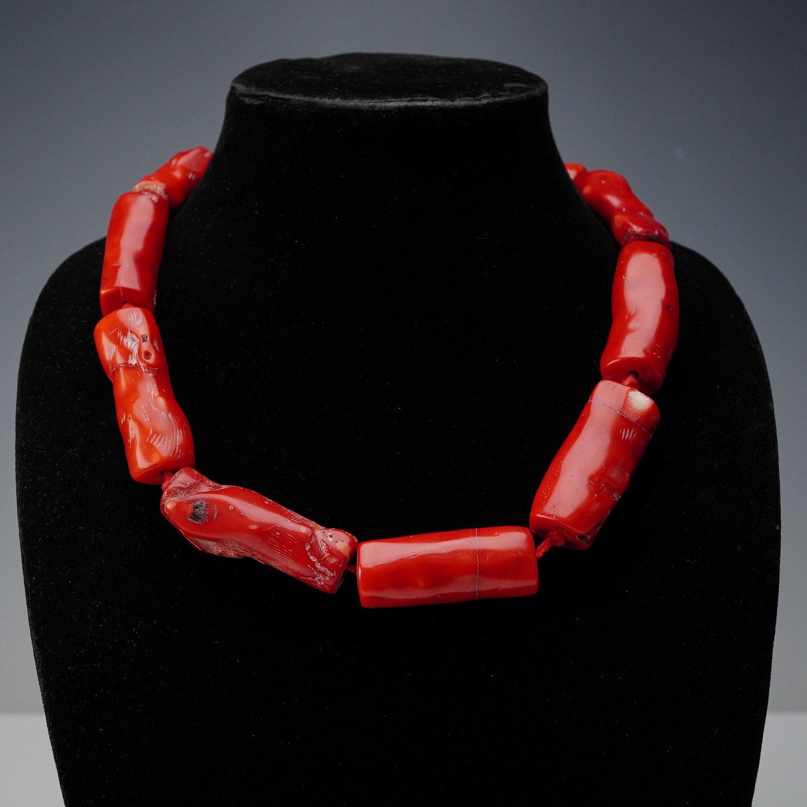 Rebecca Collins Coral and Sterling Silver Necklace: This striking necklace by Texas-based designer Rebecca Collins features large, natural branch coral beads in rich red hues, strung on a deep-toned cord with a sterling silver clasp. Each organic bead 