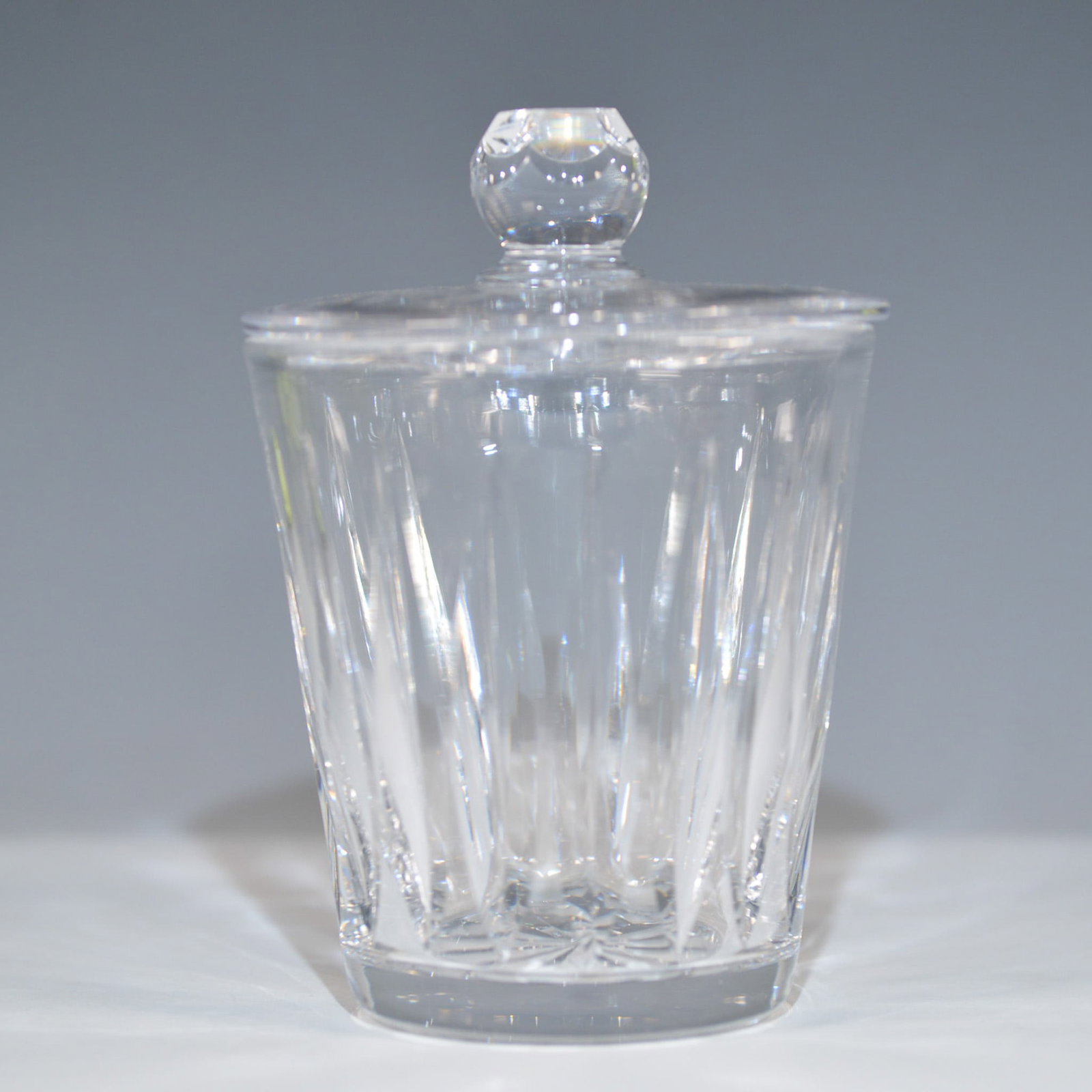 Stuart Crystal Lidded Jar, England: Elegant Stuart Crystal lidded jar featuring a vertical facet design, starburst base, and faceted finial. A fine example of British craftsmanship, Stuart Crystal was renowned for its high-quality cut g