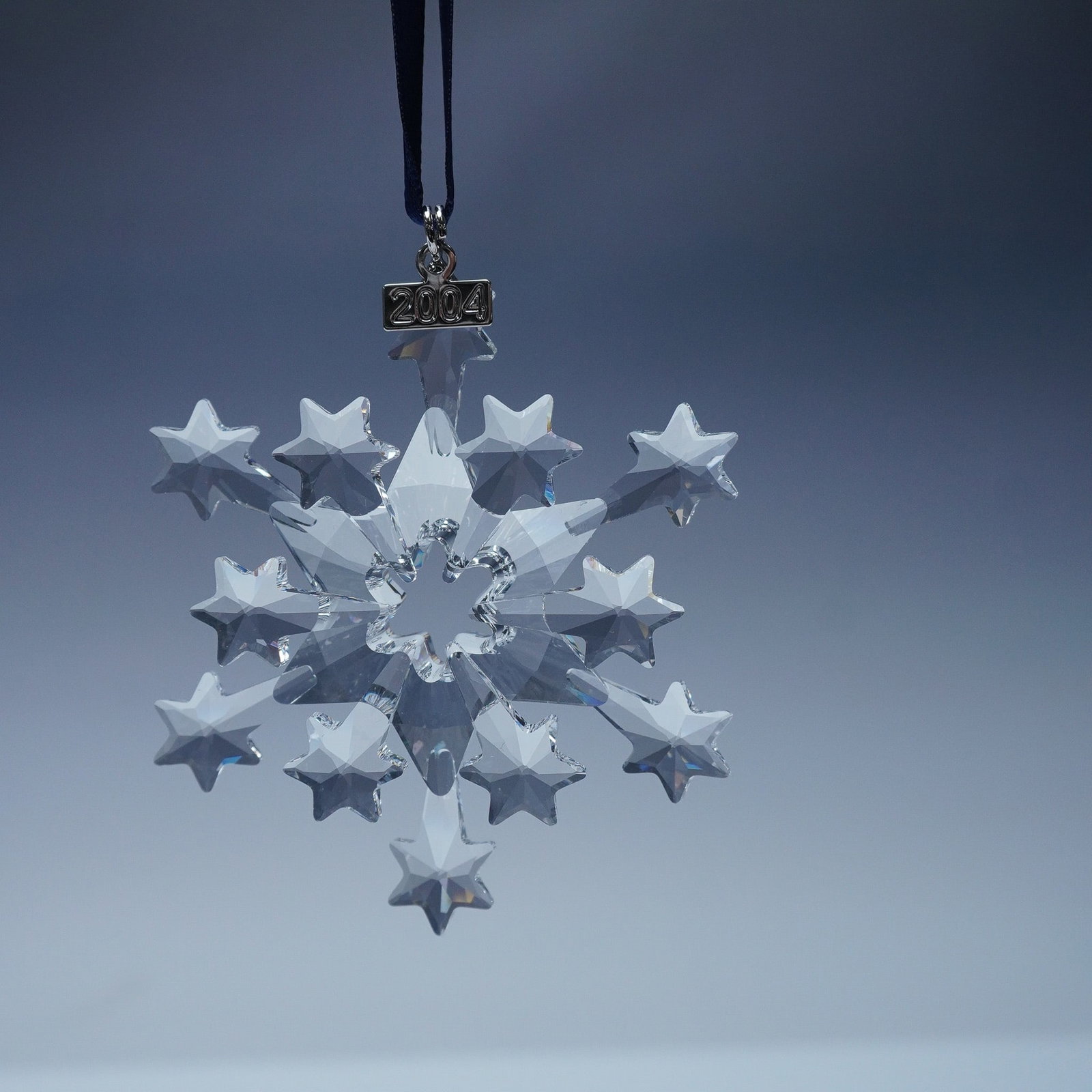 Swarovski Crystal 2004 Christmas Ornament: This limited edition Swarovski crystal ornament from 2004 showcases an exquisite snowflake-inspired design featuring twelve elegantly faceted points, with six adorned with stars and six resembling sho
