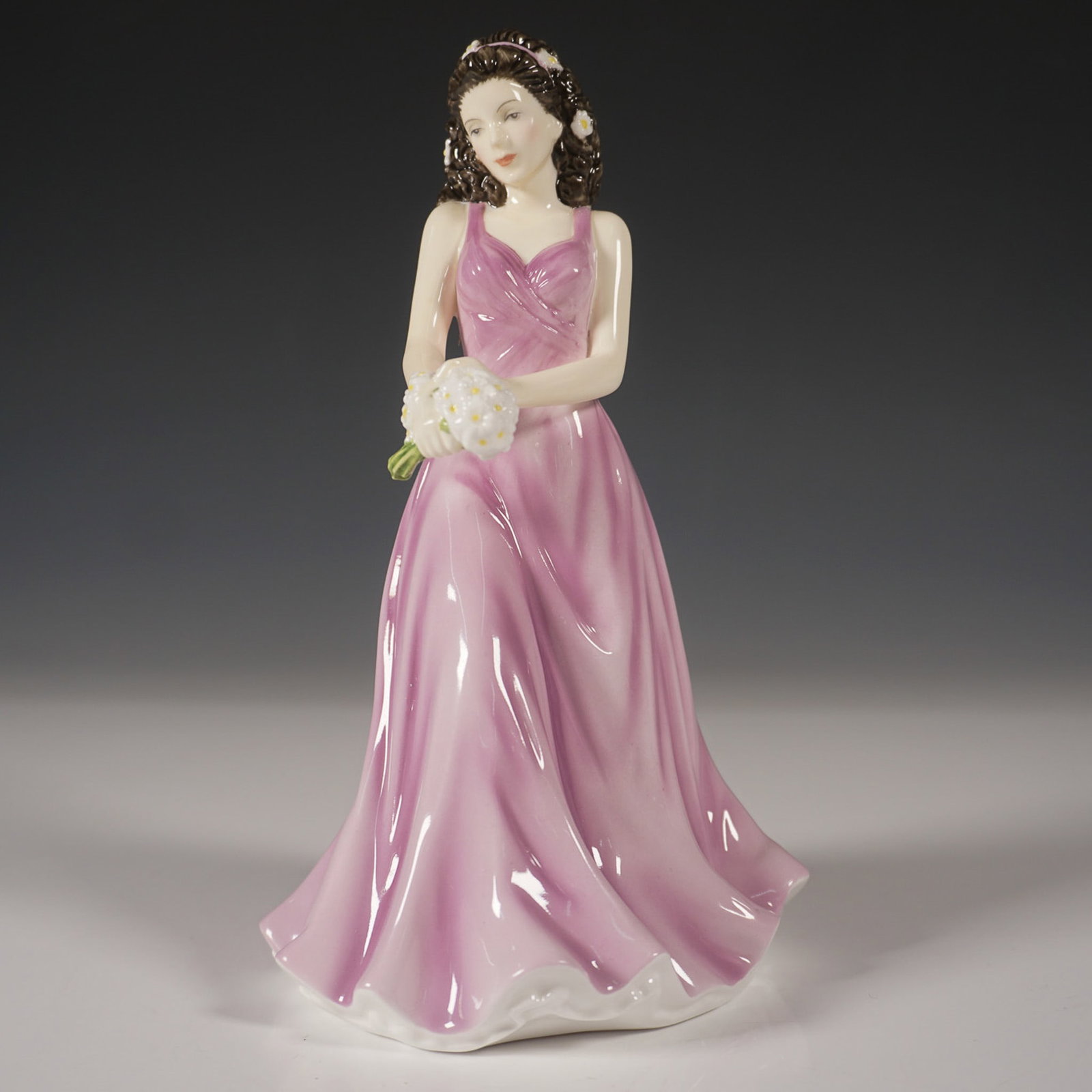Royal Doulton Flower of the Month Figurine, April HN5503: This exquisite Royal Doulton figurine, April Daisy Innocence (HN5503), is part of the Flower of the Month collection. Crafted from fine bone china, it showcases a graceful young woman in a flowing lil