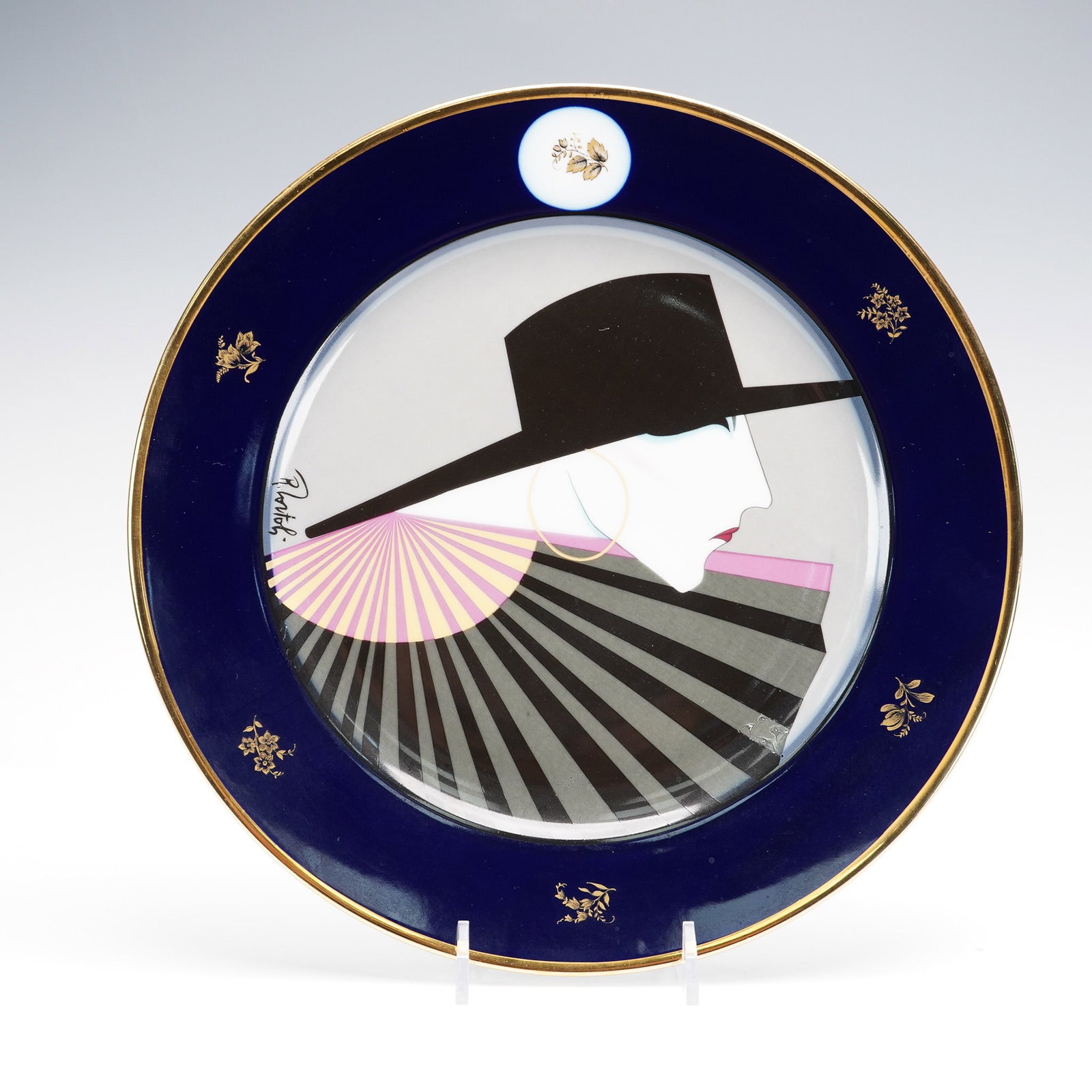 Hutschenreuther Porcelain Plate, Art Deco Woman by Roberto Tortoli: Produced by Hutschenreuther of Germany, this 10.5" diameter decorative porcelain plate showcases a bold and glamorous Art Deco-inspired portrait by Italian designer Roberto Tortoli. The composition fe