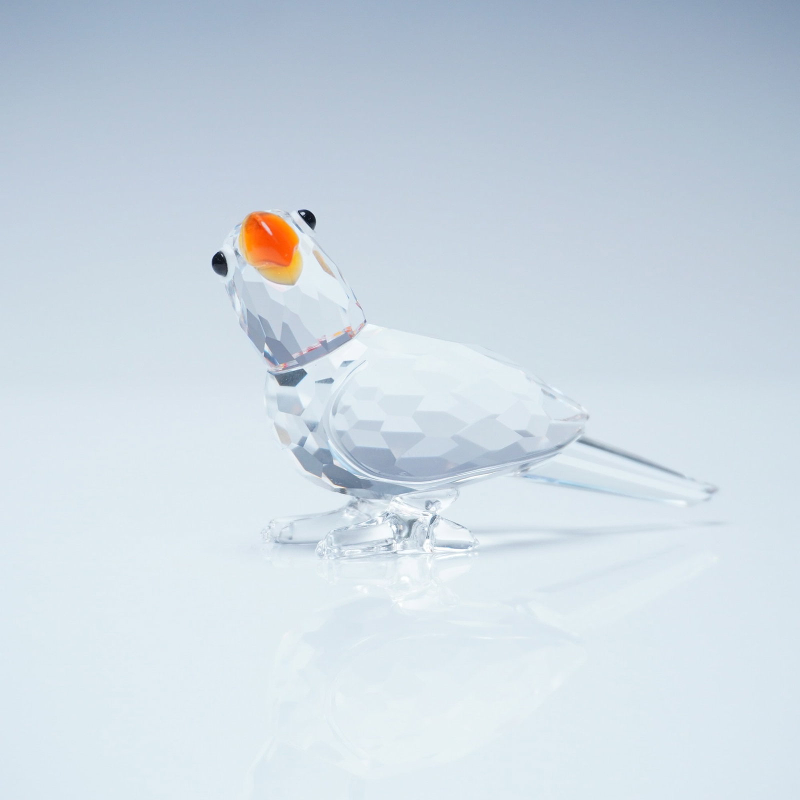 Swarovski Crystal Figurine, Cockatoo: Exquisite Swarovski crystal figurine depicting a cockatoo with a faceted clear body and an orange and black beak. This intricately designed piece showcases Swarovski's signature precision-cut crystal,
