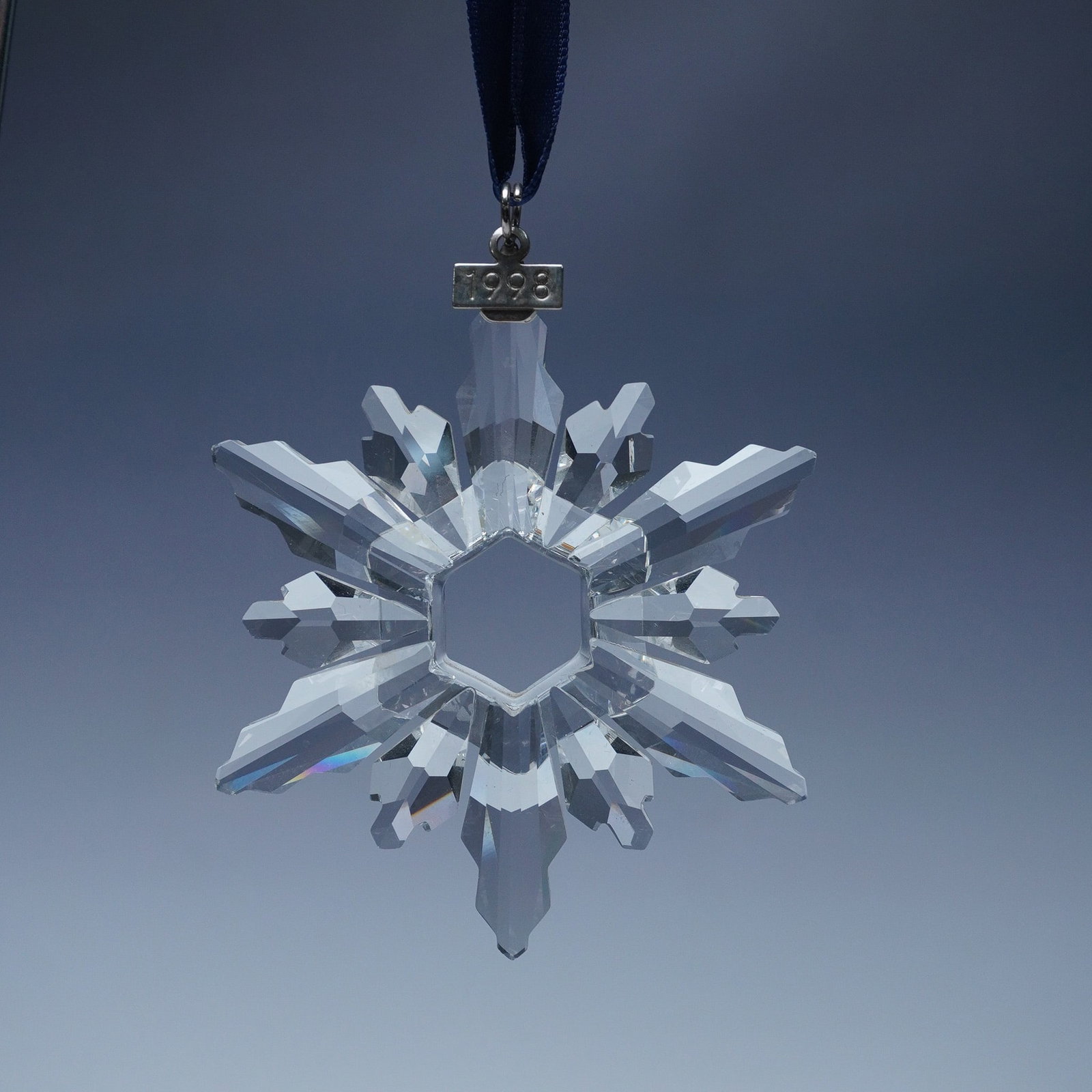 Swarovski Crystal 1998 Christmas Ornament: This retired Swarovski Christmas ornament from 1998 is part of the brand's esteemed annual holiday collection. Expertly crafted from faceted clear crystal, this delicate snowflake design features six 