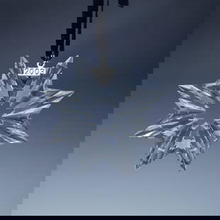 Swarovski Crystal 2003 Christmas Ornament: An addition to Swarovski's renowned Christmas ornament series, this 2003 edition showcases a beautifully faceted snowflake design with eight striking points. The expertly cut crystal reflects light br
