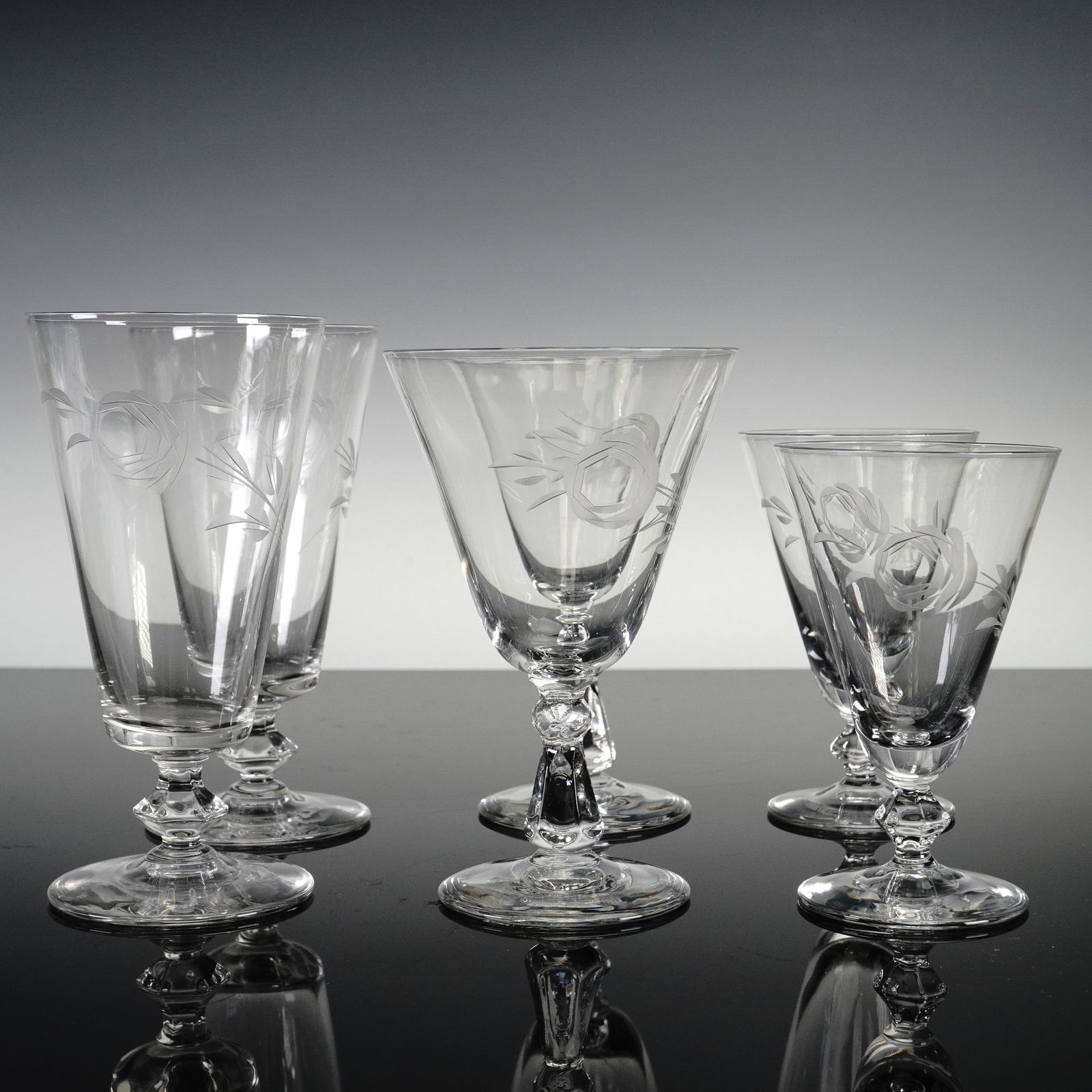 6pc Glastonbury Lotus Glasses, Arbor Rose: Set of six crystal glasses featuring stylized rose blossoms with leafy vines. This coordinated grouping includes 2 Iced tea glasses, 2 juice glasses, and 2 liquor cocktail glasses. Each piece is craft