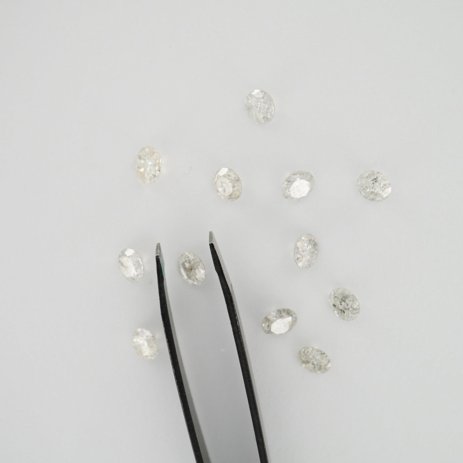 12 Loose Round Brilliant Cut Diamonds: A lot of 12 loose round brilliant cut diamonds, each weighing approximately 0.42 carats, for a total carat weight of 5.04 carats. The diamonds are graded I2 clarity, exhibiting inclusions visible unde
