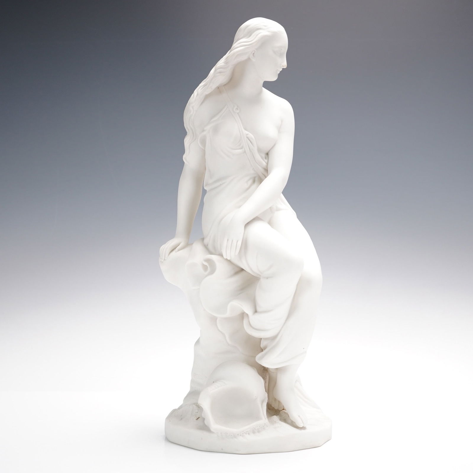 Minton Bisque Porcelain Figurine, Miranda: A finely modeled bisque porcelain figure by Minton, depicting a woman seated gracefully upon a rocky outcrop, with flowing drapery gathered modestly across her form. Her long hair cascades delicately