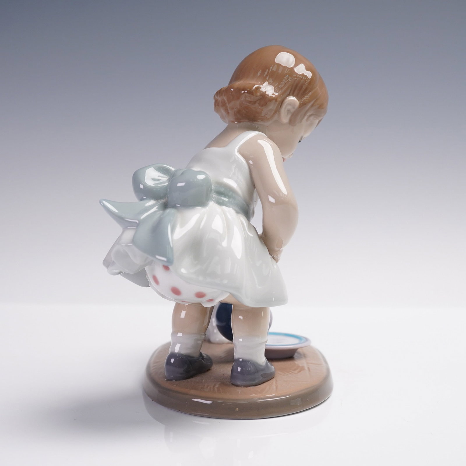 Lladro Porcelain Figurine, Kitty's Breakfast Time 01008498: Lladro Porcelain Figurine, "Kitty's Breakfast Time," model number 01008498. This charming piece features a young girl in a white dress with a pastel blue sash, carefully pouring milk from a pitcher in