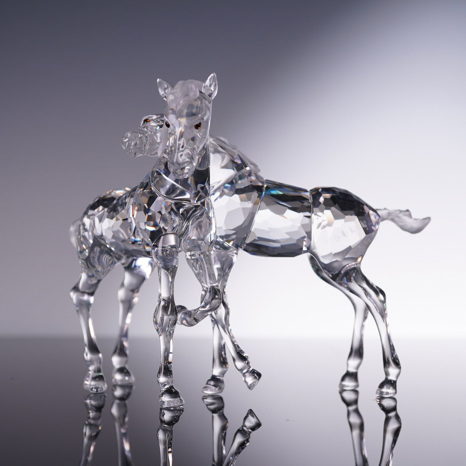 Swarovski Crystal Figurine, Foals: A charming Swarovski crystal figurine titled Foals, designed by Martin Zendron, model number 627637. This sculpture depicts two young horses in a tender, playful pose, crafted in clear faceted crystal
