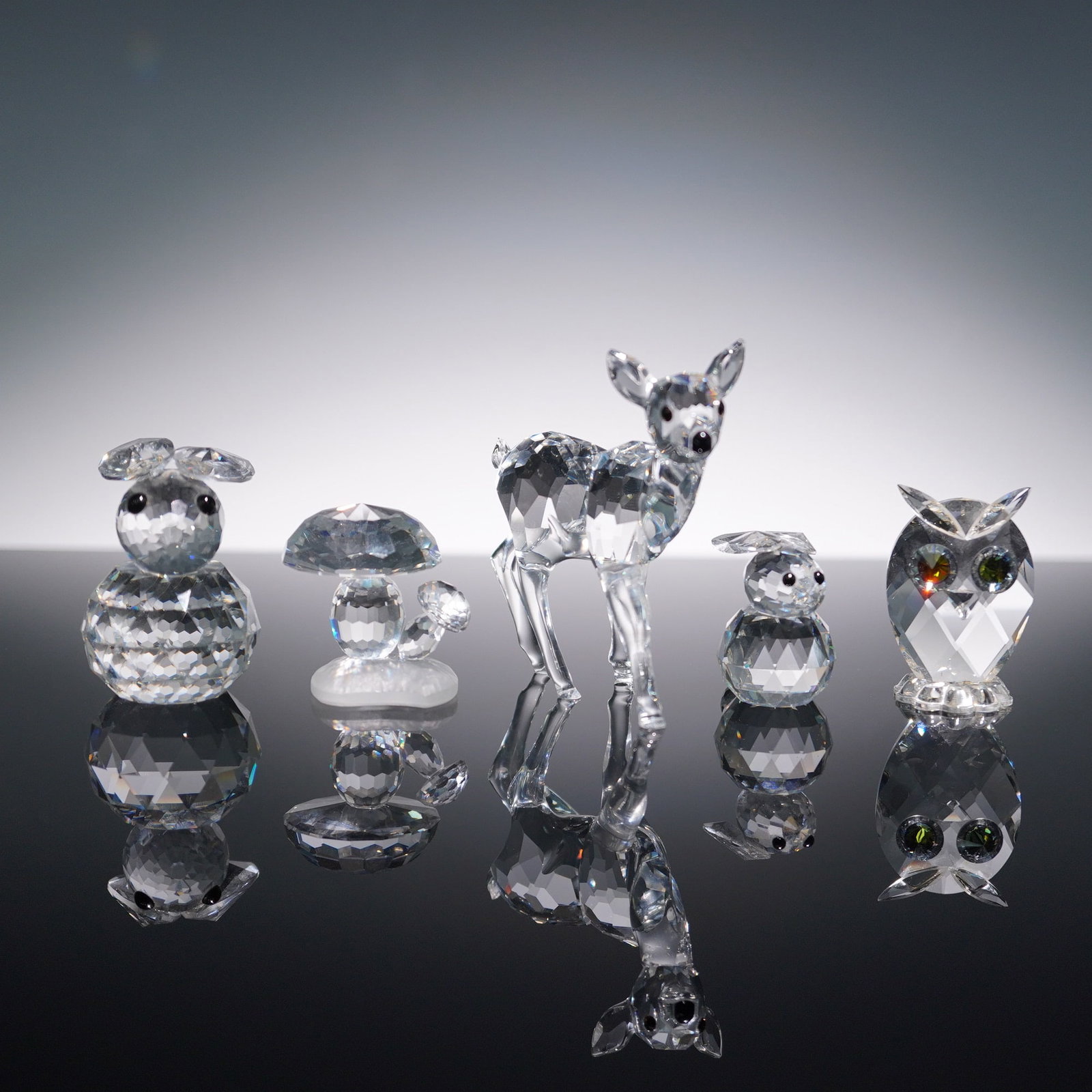 5pc Swarovski Forest Animal Figurines: This enchanting 5-piece Swarovski crystal lot features two rabbits, a mushroom, a deer, and an owl. Each figurine is expertly crafted with intricate facets that sparkle in the light, showcasing Swarov