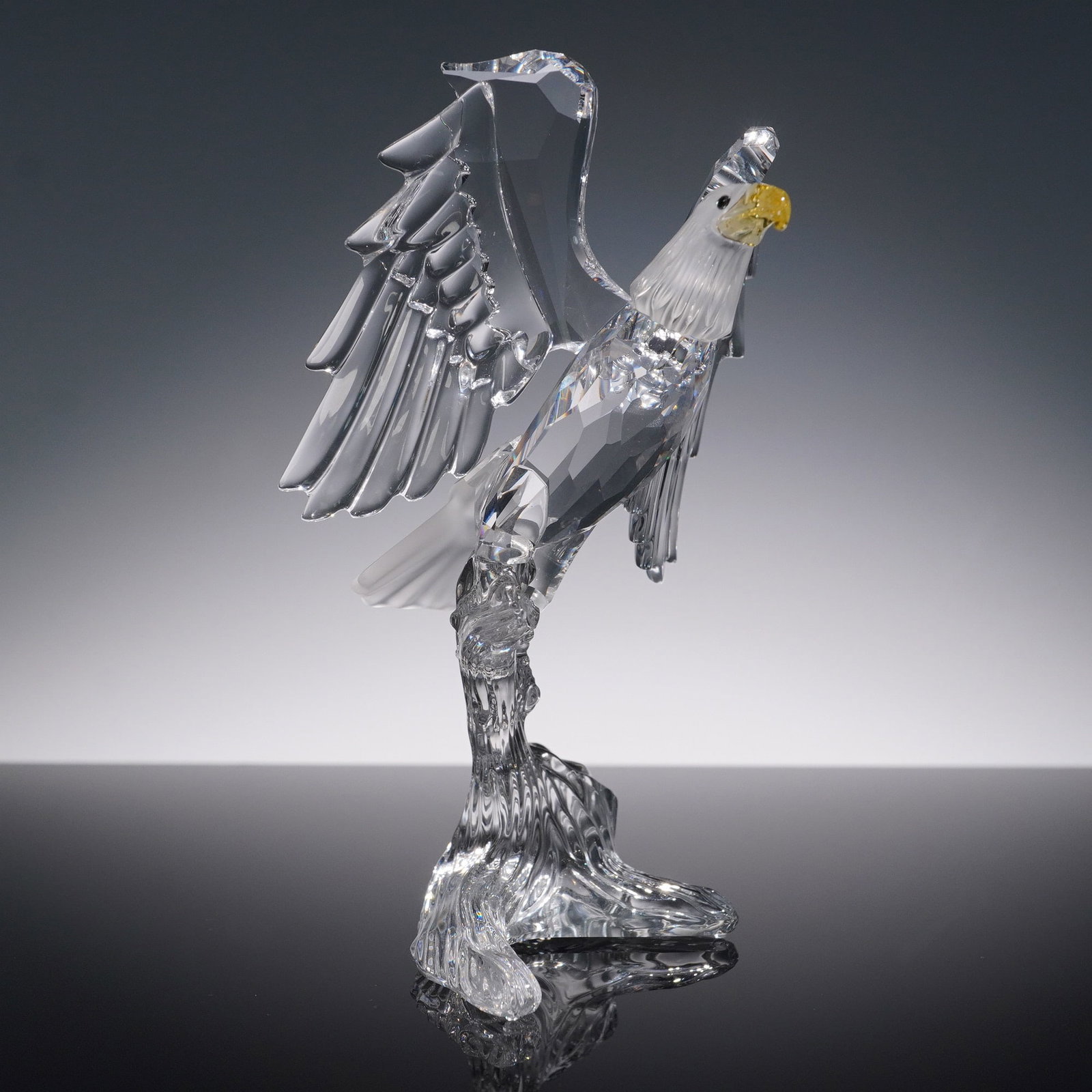 Swarovski Crystal Eagle Figurine with Box: This elegant Swarovski crystal eagle figurine captures the majesty of the bird in dazzling clear crystal, with intricate details in the feathers and a vibrant yellow beak. The figure stands poised, sh