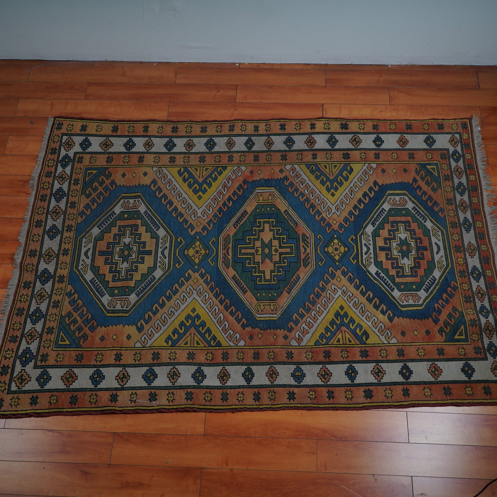 Persian Handmade Wool Kilim with Geometric Medallions & Tribal Motifs: Rich with history and bursting with vibrant tribal charm, this striking Persian handmade wool kilim features three bold central medallions framed by intricate zigzag motifs, fiery reds, indigo blues, 