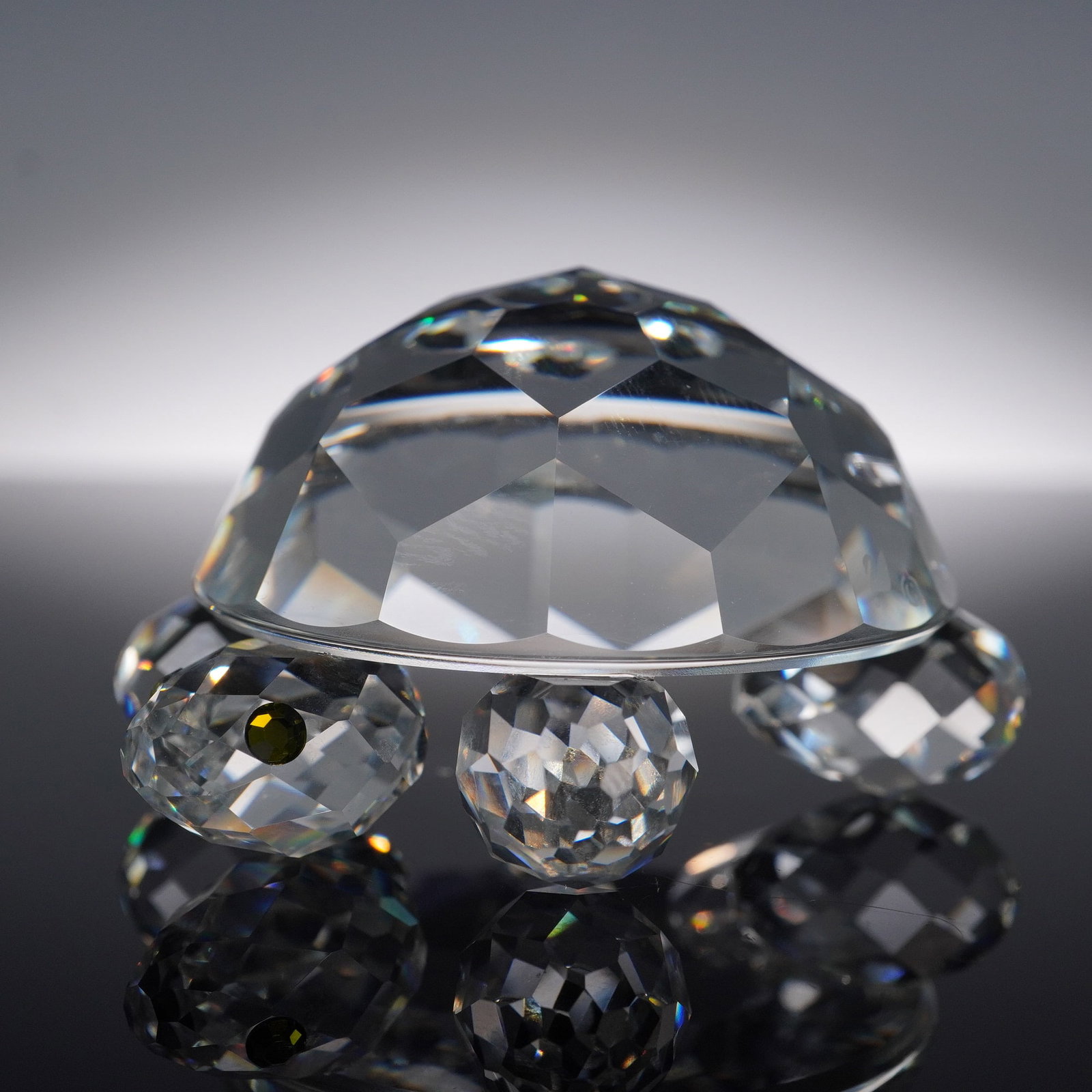 Swarovski Crystal Turtle Figurine with Original Box: Swarovski crystal turtle figurine featuring a large faceted domed shell and four round faceted feet, accented by jet black eyes. The precision-cut surfaces catch and reflect light with exceptional bri