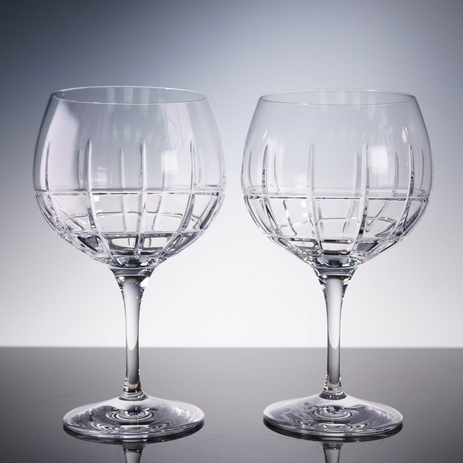 Pair of Waterford Crystal Gin Journeys Cluin Balloon Goblets: A stylish pair of Waterford Crystal balloon goblets from the Gin Journeys collection, featuring the "Cluin" pattern. These wide-bowled glasses are designed to enhance the aromatics of your favorite gi