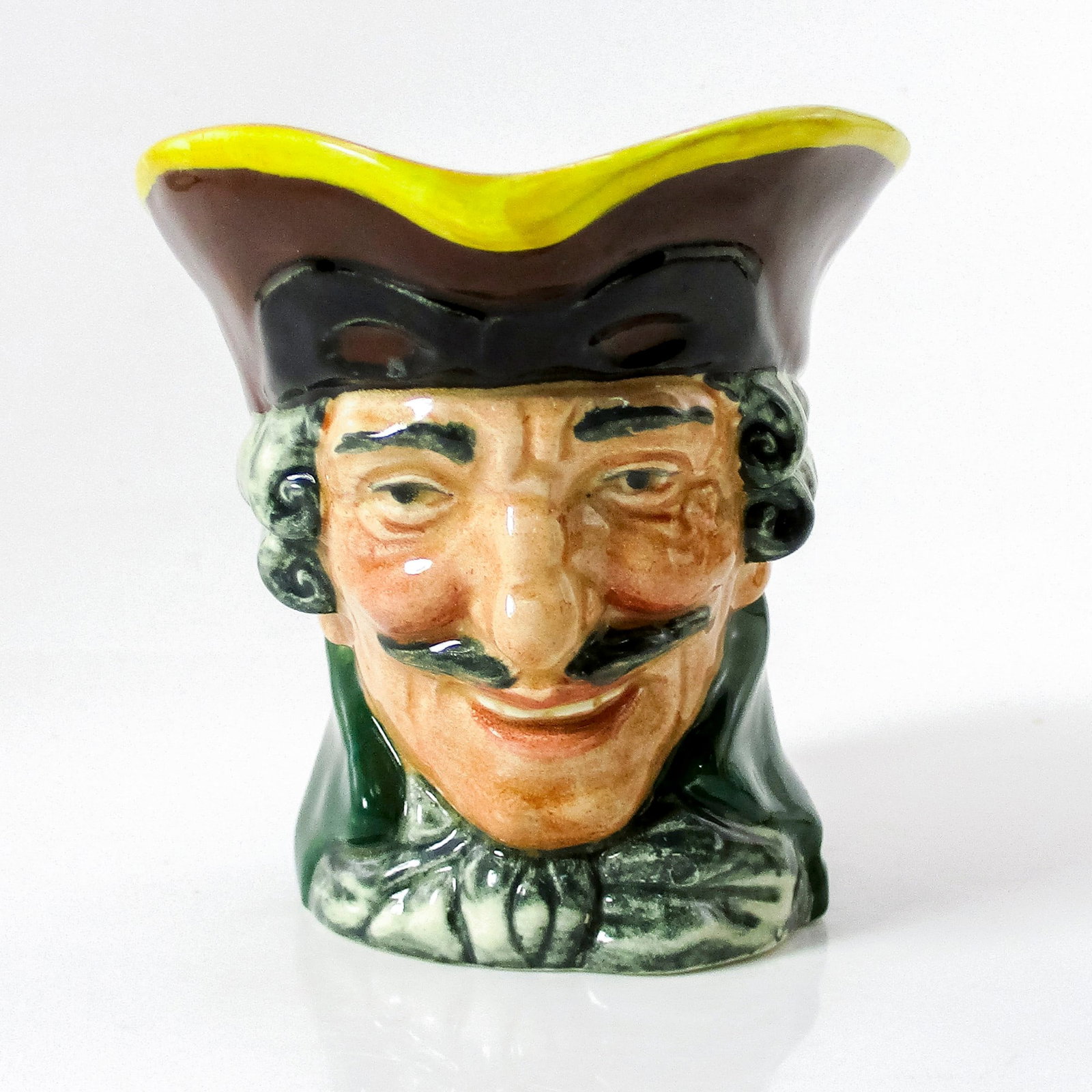 Dick Turpin D5618 Small Doulton Character Jug: Style One. Brown hat; black mask up; green coat; white cravat. Dick Turpin (1705 - 1739) joined forces with fellow highwayman Tom King, whom he accidentally shot. Before he died, King betrayed him. Th