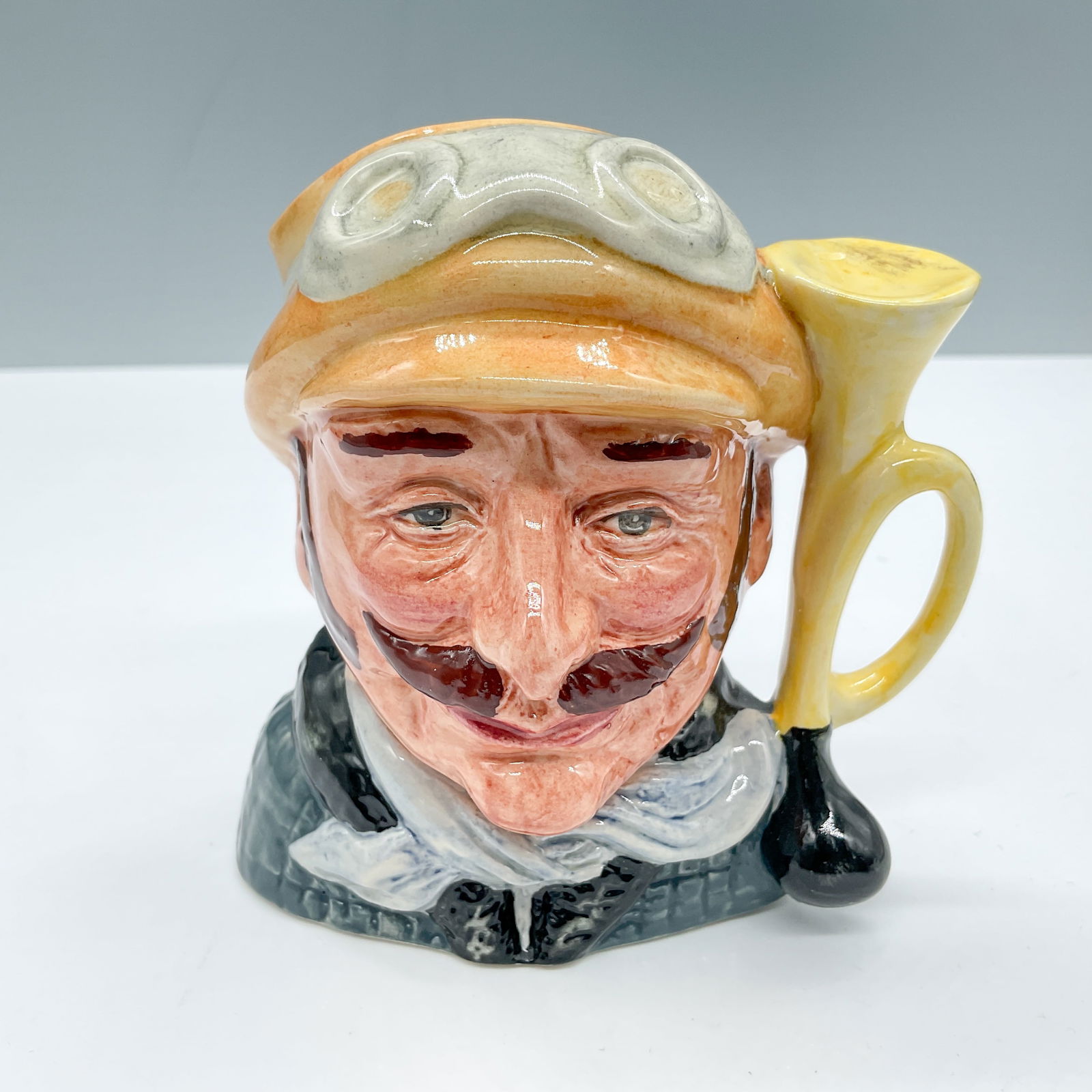 Veteran Motorist D6637 - Small - Royal Doulton Character Jug: Royal Doulton backstamp. Artist: David B. Biggs Issued: 1973 - 1983 Dimensions: 3.25"H Country of Origin: England