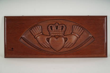 Heritage Hand-Carved Mahogany Wall Panel, Claddagh Symbol: Heritage mahogany wall panel intricately hand-carved with the traditional Irish Claddagh motif, symbolizing love, loyalty, and friendship. The central design features two hands cradling a heart topped