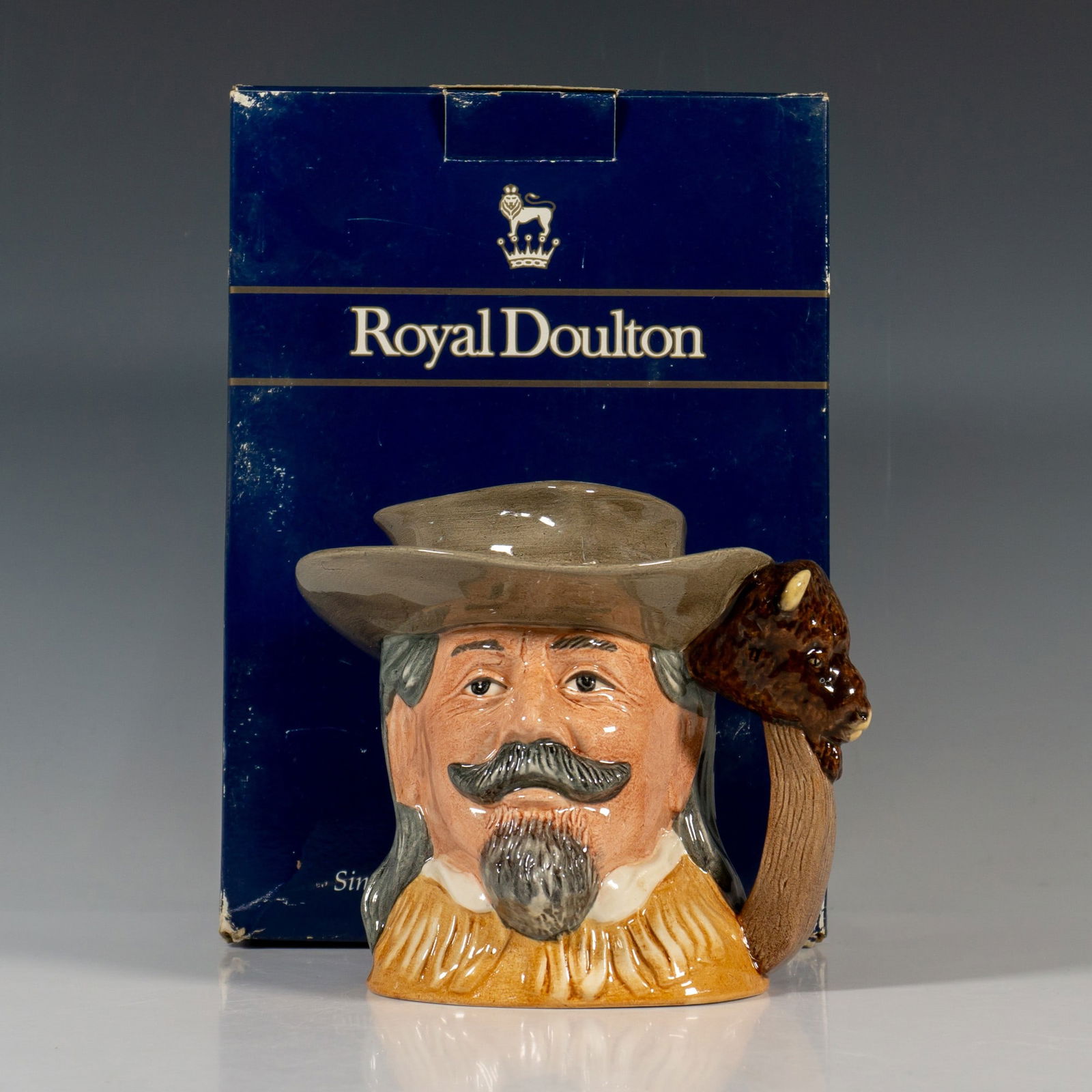 Buffalo Bill D6735 - Odd - Royal Doulton Character Jug: This character jug, part of the Wild West Collection, features a light brown hat and buckskin jacket. William Frederick Cody (1846 -1917), known as Buffalo Bill, was a legendary figure. His exceptiona