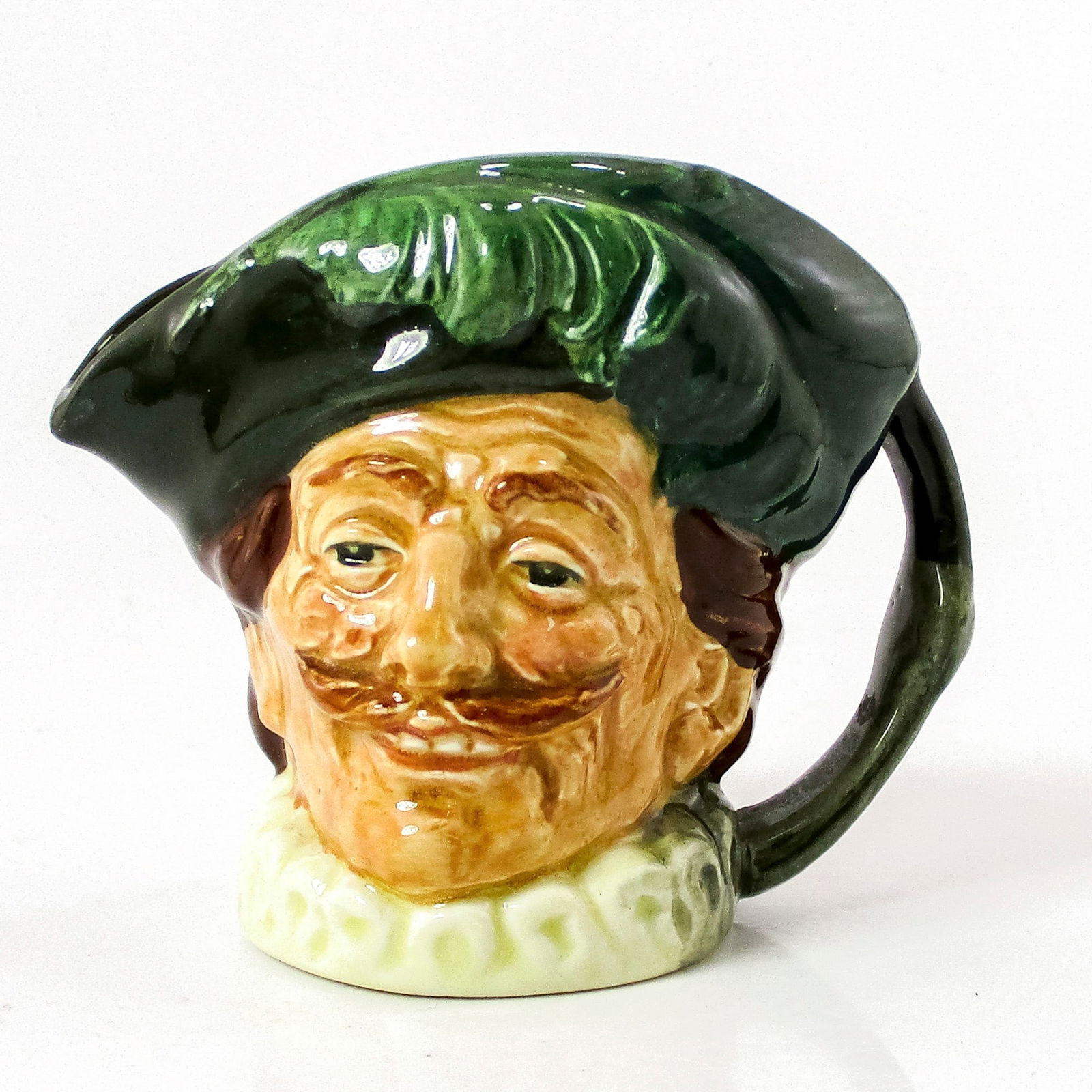 Cavalier D6173 - Small - Royal Doulton Character Jug: Style Two, without goatee. Green hat; white ruff. This jug was originally listed in Royal Doulton's product guide as the Laughing Cavalier, presumably after the famous Frans Hals painting. Slight colo