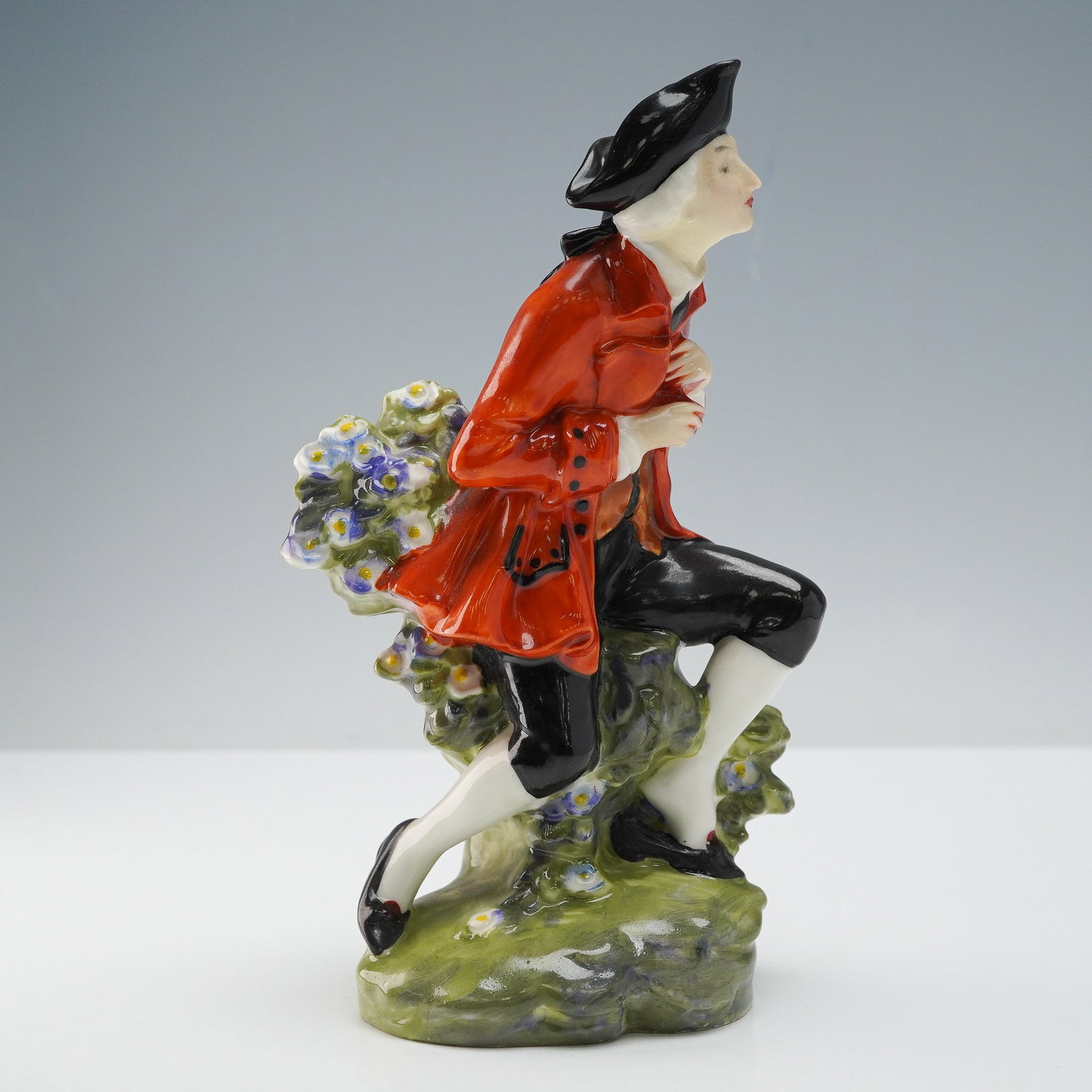 Royal Doulton Figurine, The Chelsea Pair Man HN579: Royal Doulton figurine titled The Chelsea Pair, model HN579, depicting a courtly gentleman in a red frock coat with black tricorn hat and breeches, posed on a flowering base. Hand-painted in vibrant g