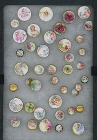 A tray of hand painted ceramic stud buttons