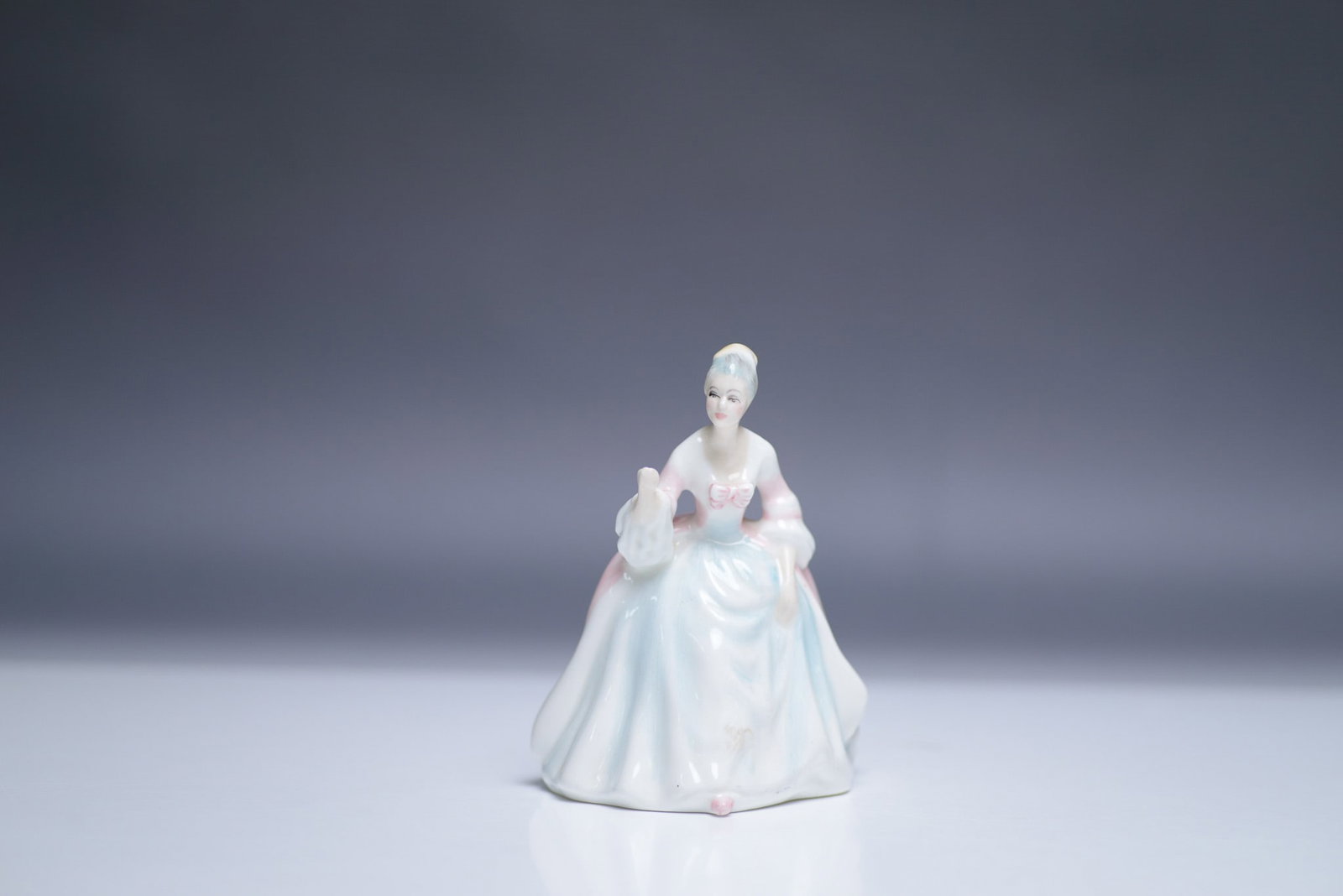 Royal Doulton Mini Figurine Diana HN 3310, Boxed: A graceful and finely detailed Royal Doulton figurine, Diana HN 3310, designed by Peggy Davies. This elegant piece portrays a poised lady in a flowing pastel gown with soft blue and pink hues, evoking