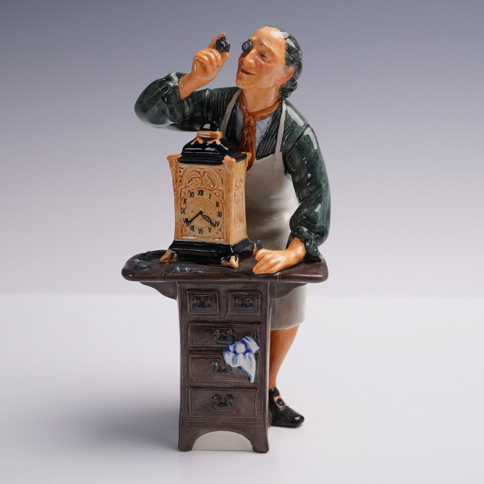 Royal Doulton Figurine, The Clockmaker, HN2279: This listing features a highly collectible Royal Doulton figurine titled "The Clockmaker", model HN2279, designed by Charles Noke and first issued in 1970. Crafted in England, this hand-painted porcel
