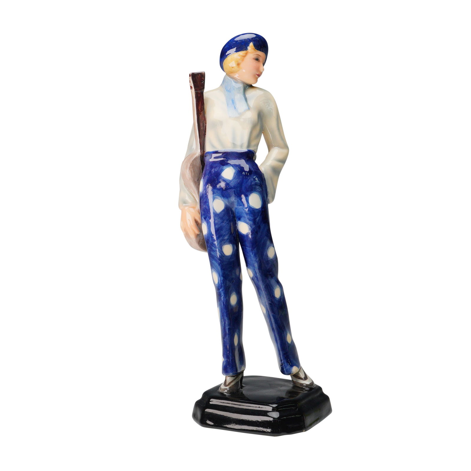 Goldscheider Figure, Stefan Dakon: A finely modeled Art Deco ceramic figure designed by Stefan Dakon for Goldscheider, Austria. The subject is a poised young woman in vivid cobalt blue high-waisted polka dot trousers, paired with a sof