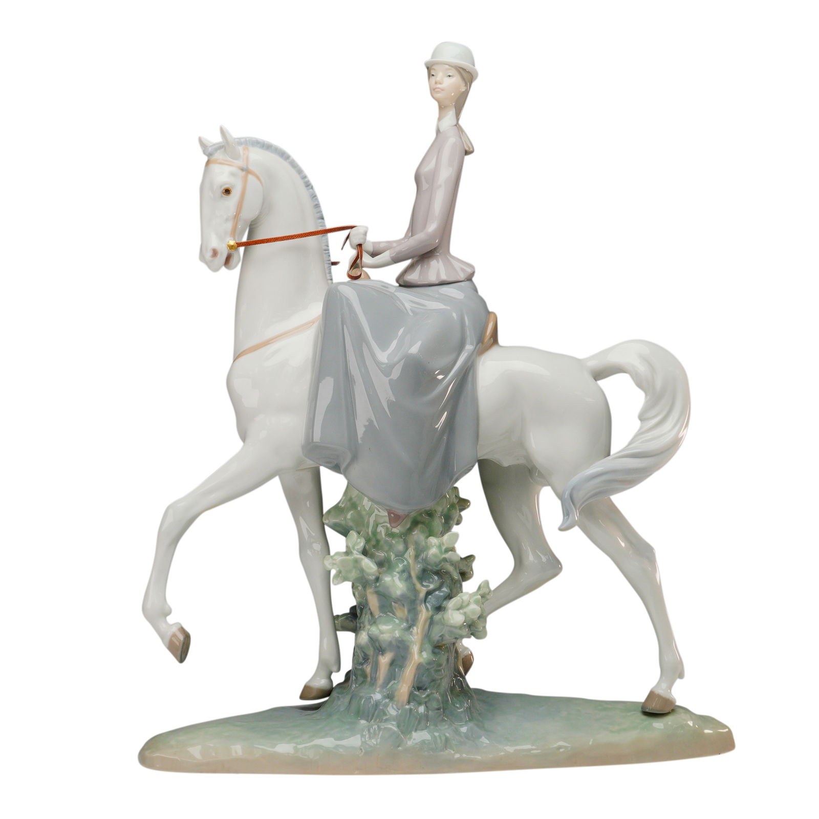 Lladro Porcelain Figurine, Female Equestrian 1004516: Lladro porcelain figurine titled "Female Equestrian" (Spanish: Amazona), sculpted by Fulgencio Garcia. Issued in 1970, this elegant piece depicts a poised lady in riding attire seated side-saddle on a