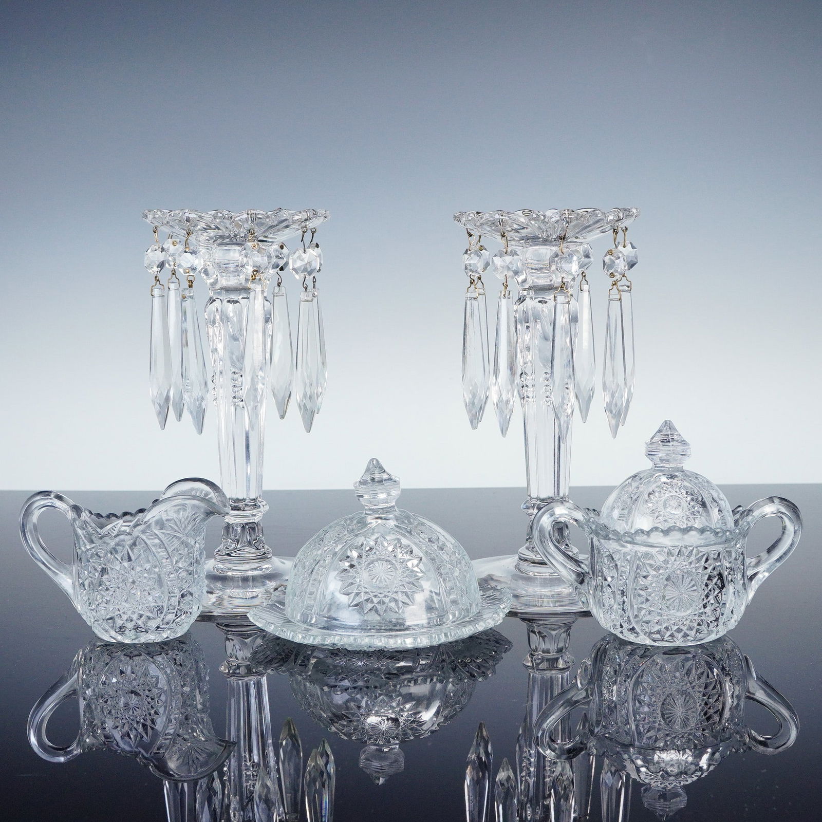 7pc Pressed Glass Set with Crystal Lusters and Table Pieces: This 7-piece pressed glass set includes a pair of elegant mantle lusters adorned with faceted spear prisms and scalloped rims, crafted in a classic Victorian-style design with fluted columns and fine