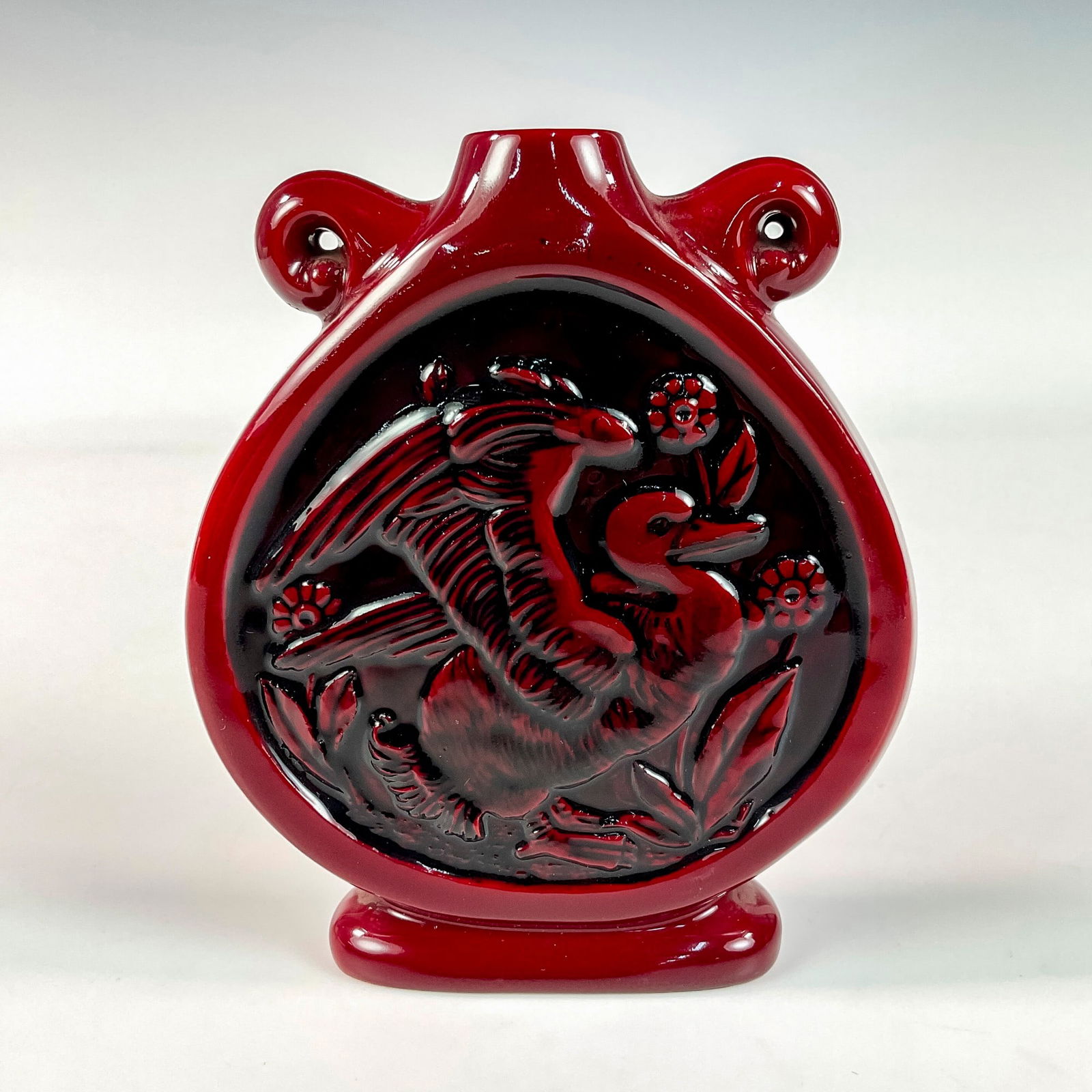 Royal Doulton Flambe Prototype Moon Flask: Very rare, early piece in a rich red glaze, decorated in a low relief with flowers and a grass duck. Artist initials "M. G." marked to base. Model no. 3077 impressed to bottom. Royal Doulton Flambe ba