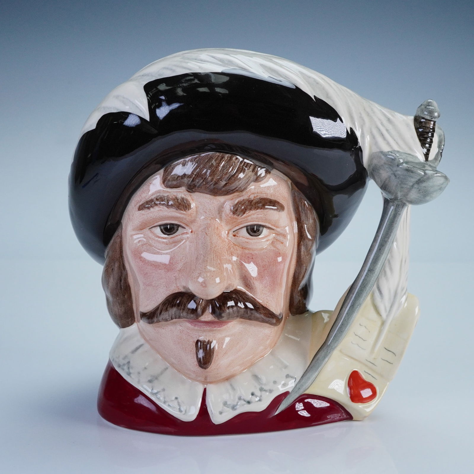 Royal Doulton Character Jug, Cyrano de Bergerac D7004: Royal Doulton character jug titled Cyrano de Bergerac, model number D7101. Issued in 1995 and modeled by David B. Biggs, this large-size jug portrays the iconic 17th-century French dramatist with a fe