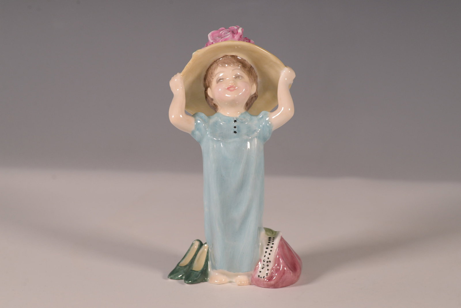 Royal Doulton Figurine Make Believe HN2225: The Make Believe figurine (HN2225) by Royal Doulton, introduced in 1961, beautifully captures the innocence and imagination of childhood. This charming piece features a young girl playfully holding a 