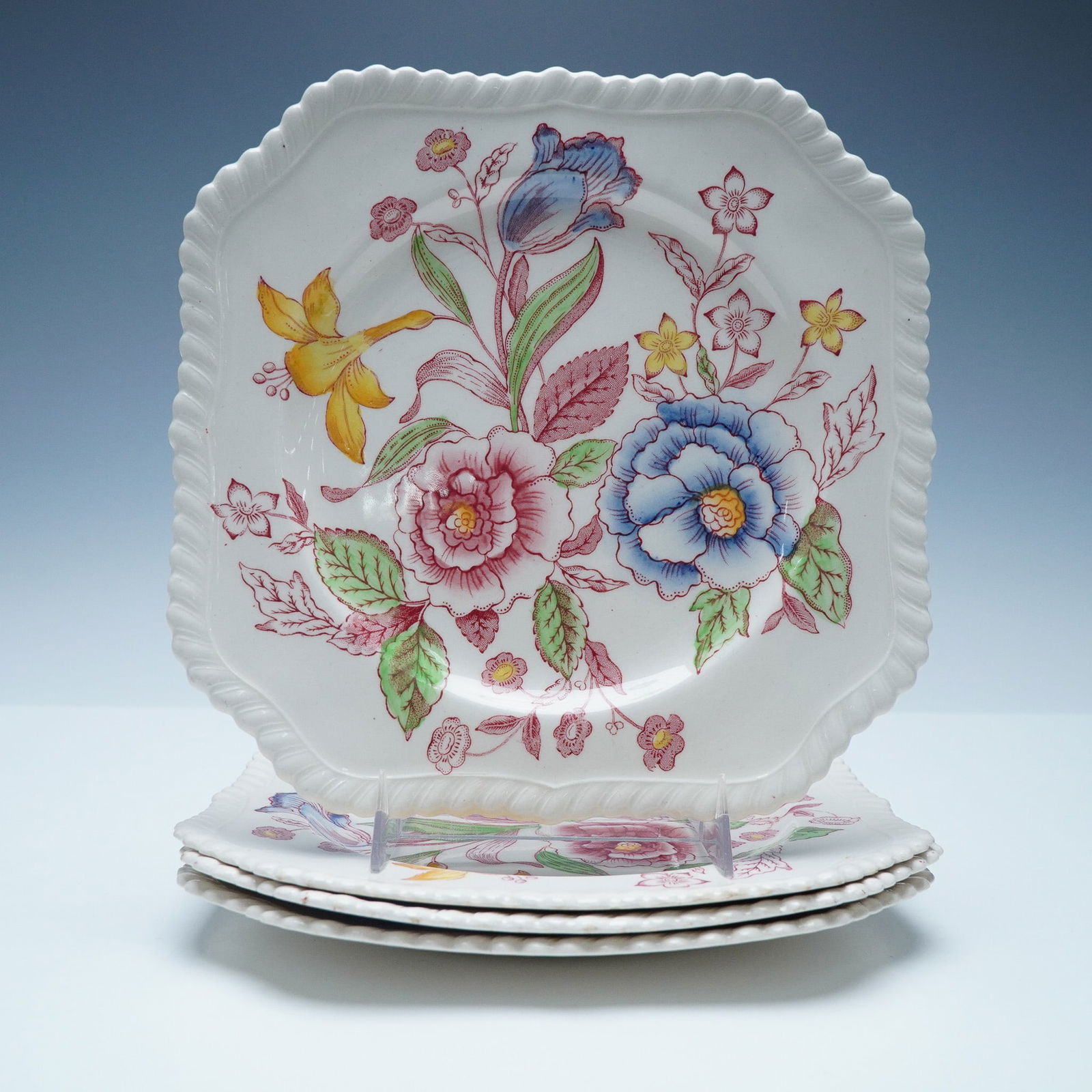4pc Johnson Bros English Bouquet Square Plates: A set of four Johnson Bros English Bouquet square plates, featuring a beautifully detailed floral pattern in vibrant shades of blue, pink, yellow, and green. The plates have a distinctive square shape