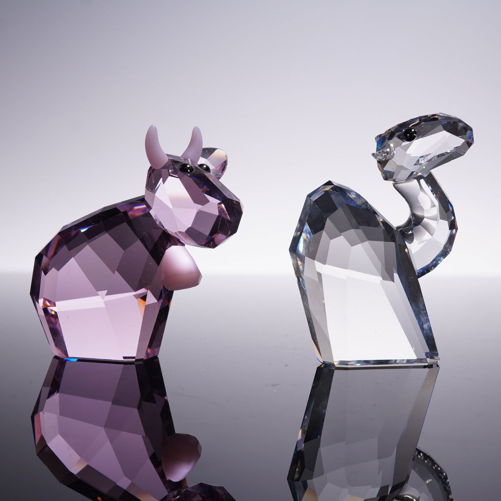2pc Swarovski Lovlots Figurines Pinky Mo and Lay Z Camel: Pair of Swarovski crystal Lovlots figurines featuring Pinky Mo the pink cow and Lay Z the camel. Each figure is crafted in faceted crystal with expressive details and black crystal eyes, both standing