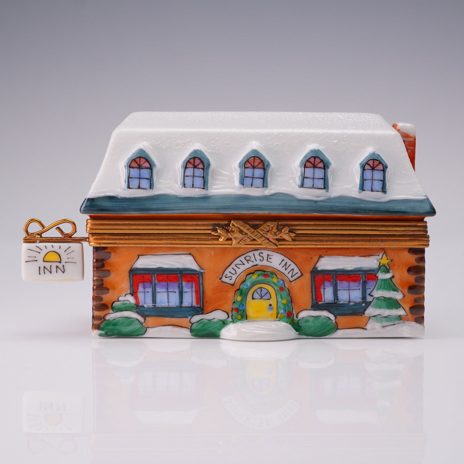 Limoges Porcelain Jewelry Box Sunrise Inn Marquise de Pompadour: Charming Limoges porcelain jewelry box in the form of a snow-covered Sunrise Inn with festive painted wreath and trees, featuring a sculpted roof with five dormer windows and a hanging inn sign. Marke