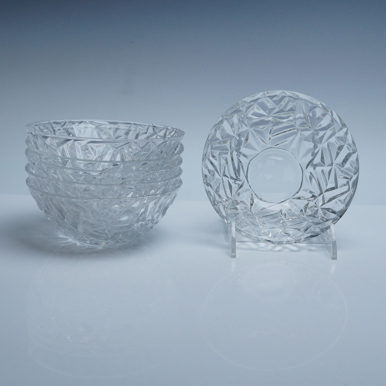 6pc Tiffany and Co Rock Cut Crystal Bowls: Set of six crystal bowls by Tiffany and Co, each with sharply faceted geometric surfaces designed to catch and refract light in striking angles. Acid-etched Tiffany and Co marks to the base. Known for