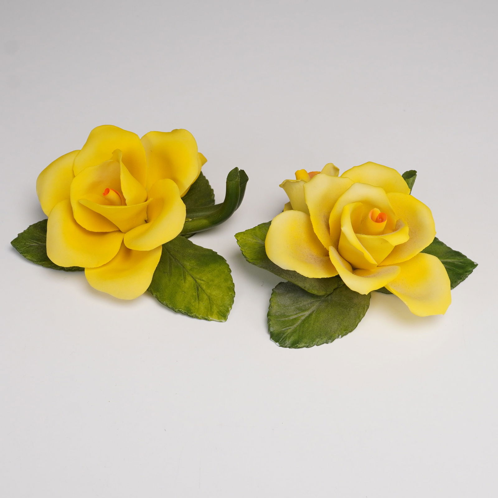 2pc Fabar Capodimonte Porcelain Figurnies, Yellow Rose: A pair of Italian Capodimonte porcelain yellow rose floral sculptures by Fabar. Each figural bloom is hand-molded and painted in vibrant yellow with green foliage, featuring realistic veining and peta