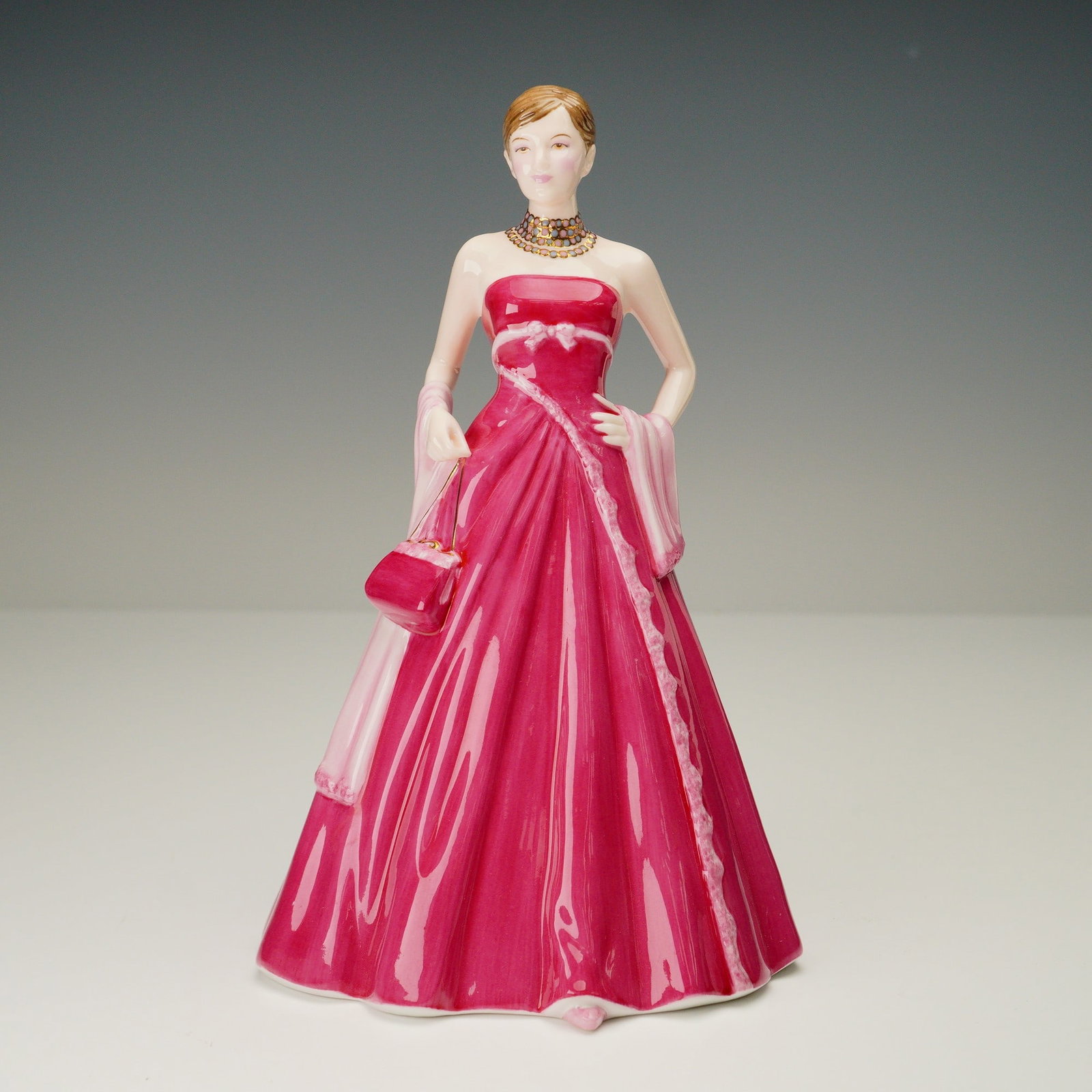 Royal Doulton Figurine, Happy Birthday 2005 HN4722: A stylish Royal Doulton bone china figurine from the Pretty Ladies collection, titled Happy Birthday 2005. Designed by Nada Pedley, this hand-decorated piece portrays an elegant young woman dressed fo