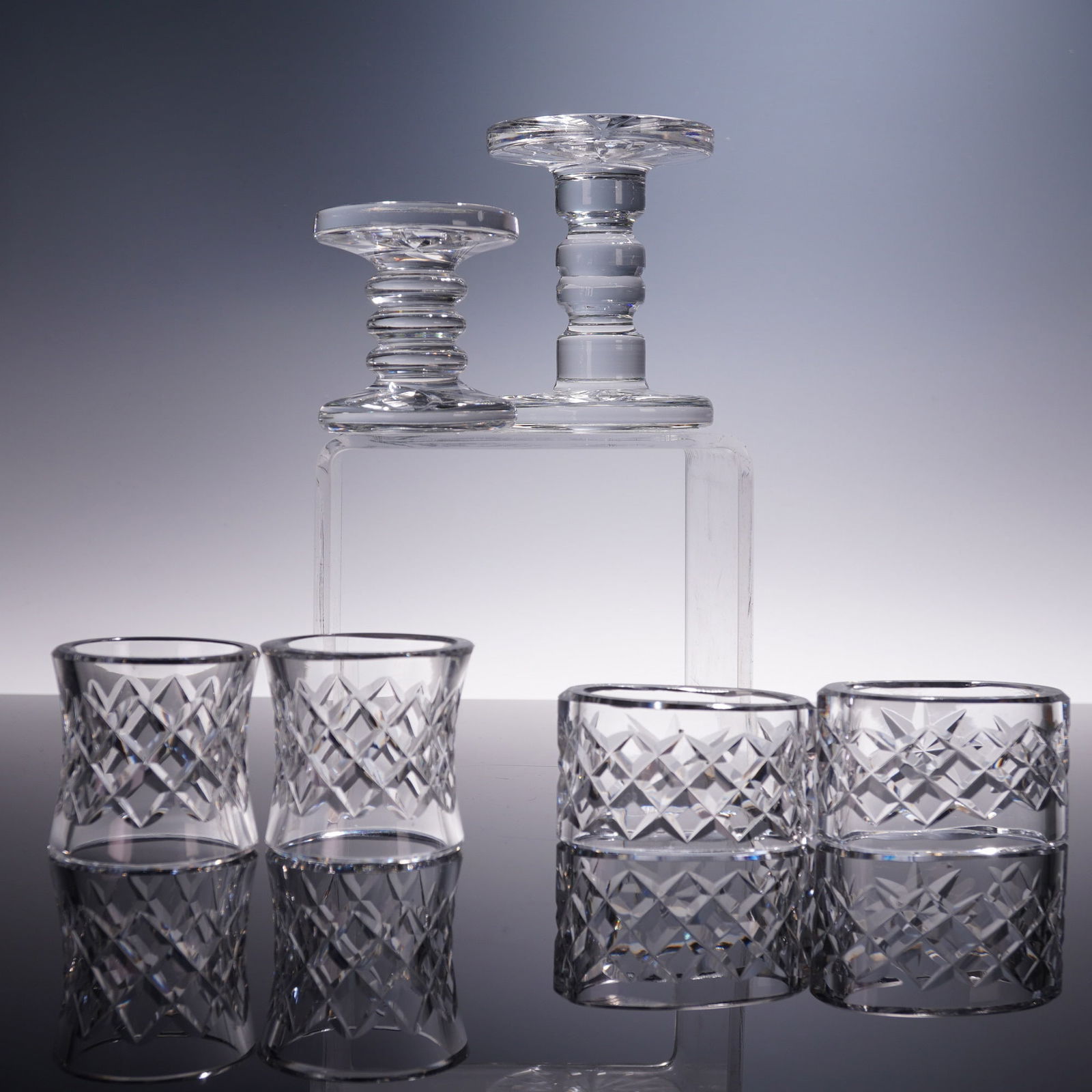 6pc Waterford Crystal Tableware: Knife Rest, Salt Cellars & Napkin Rings: An elegant set of six Waterford crystal table accessories, comprising four napkin rings and two knife rests. The napkin rings are crafted in a mix of round and oval forms, each featuring the iconic cr